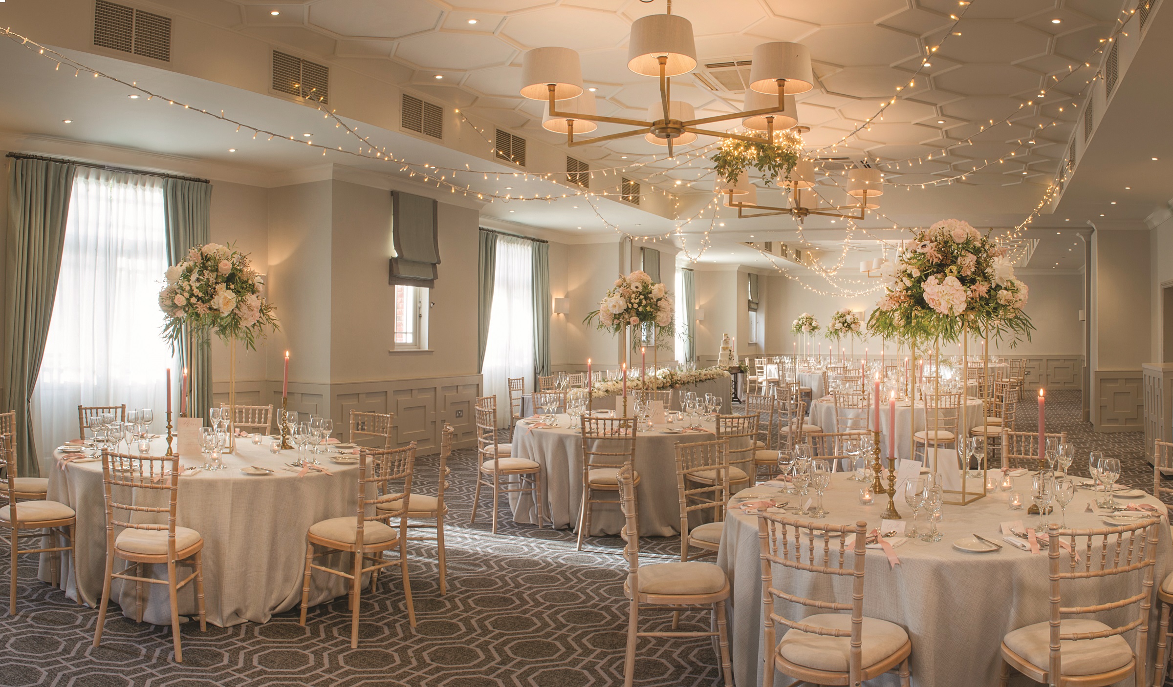 Evelyn Suite at Wotton House, elegant wedding venue with floral centerpieces and fairy lights.
