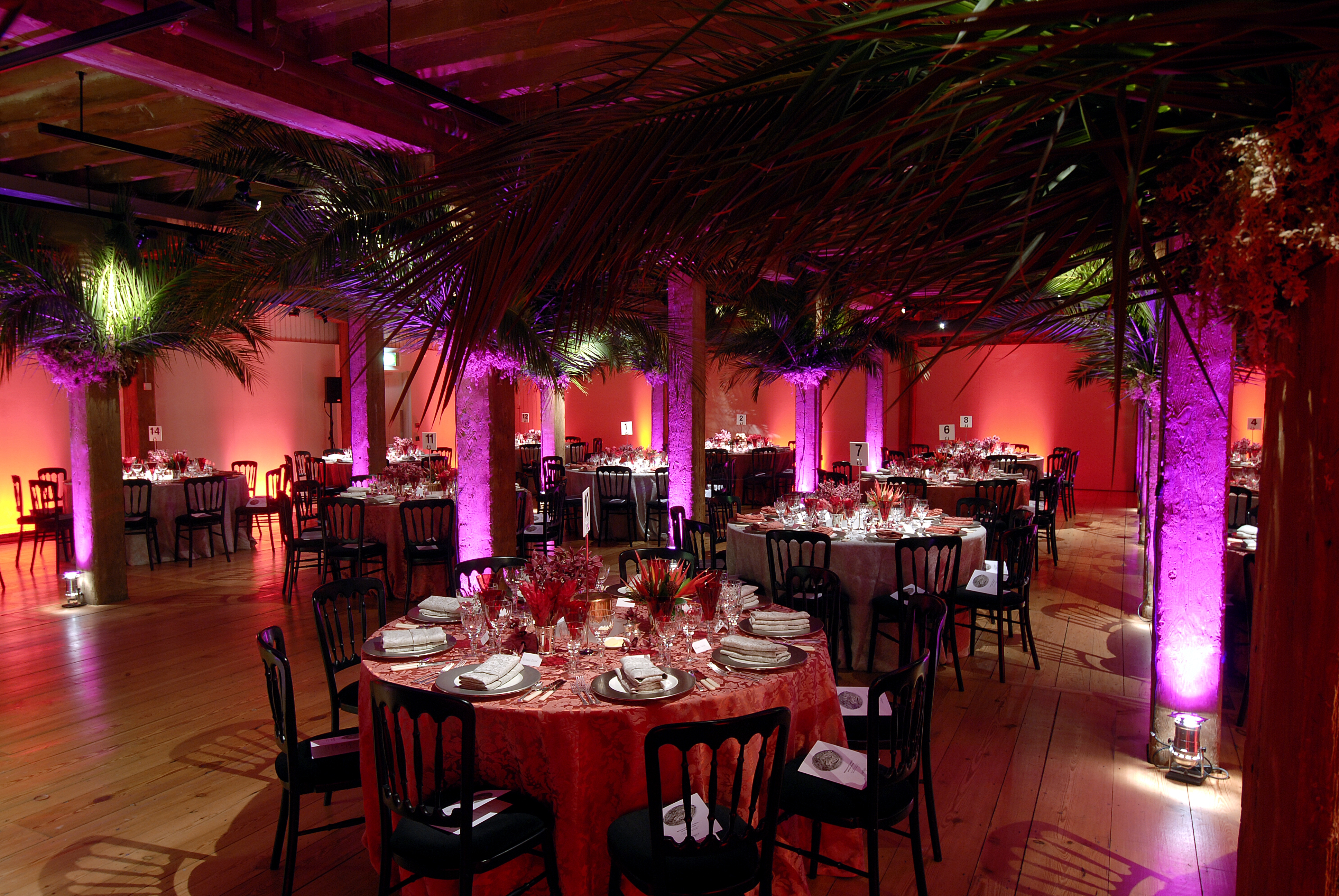 Elegant event space at London Museum Docklands with floral centerpieces and warm lighting.