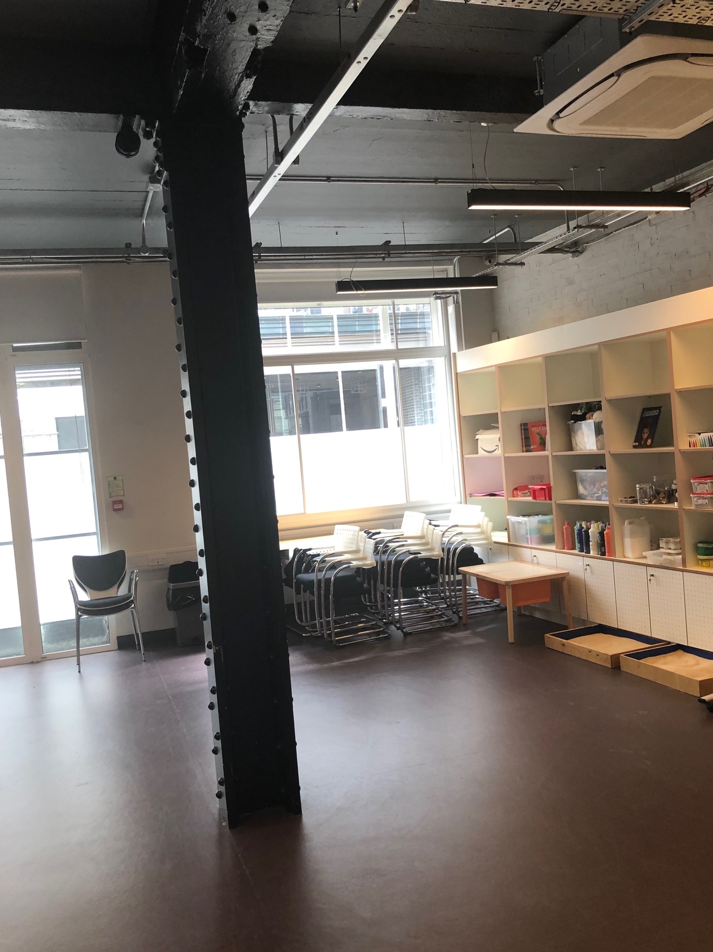 Versatile training room with natural light, ideal for workshops and gatherings.