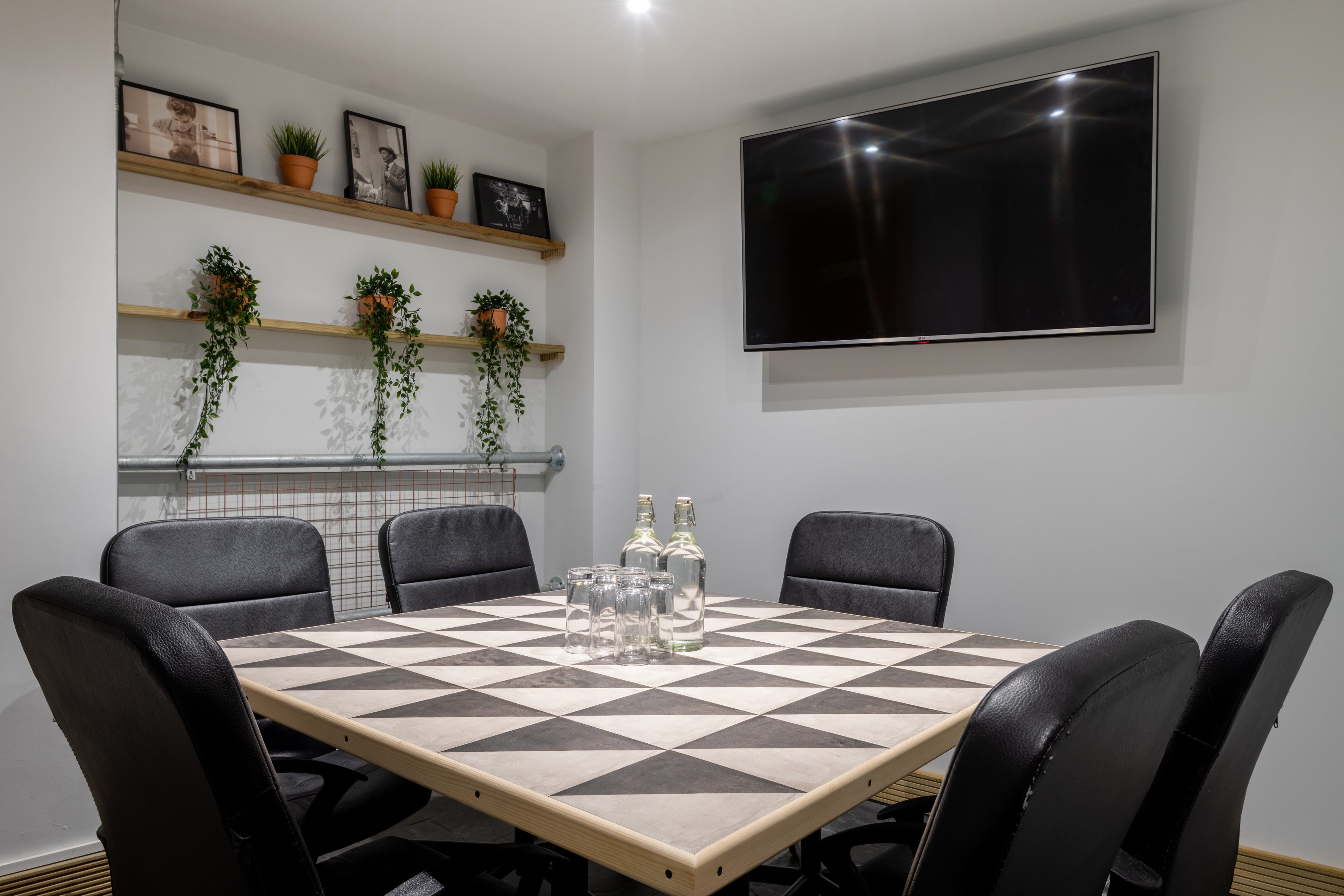 Modern meeting room with geometric table, ideal for collaborative brainstorming sessions.