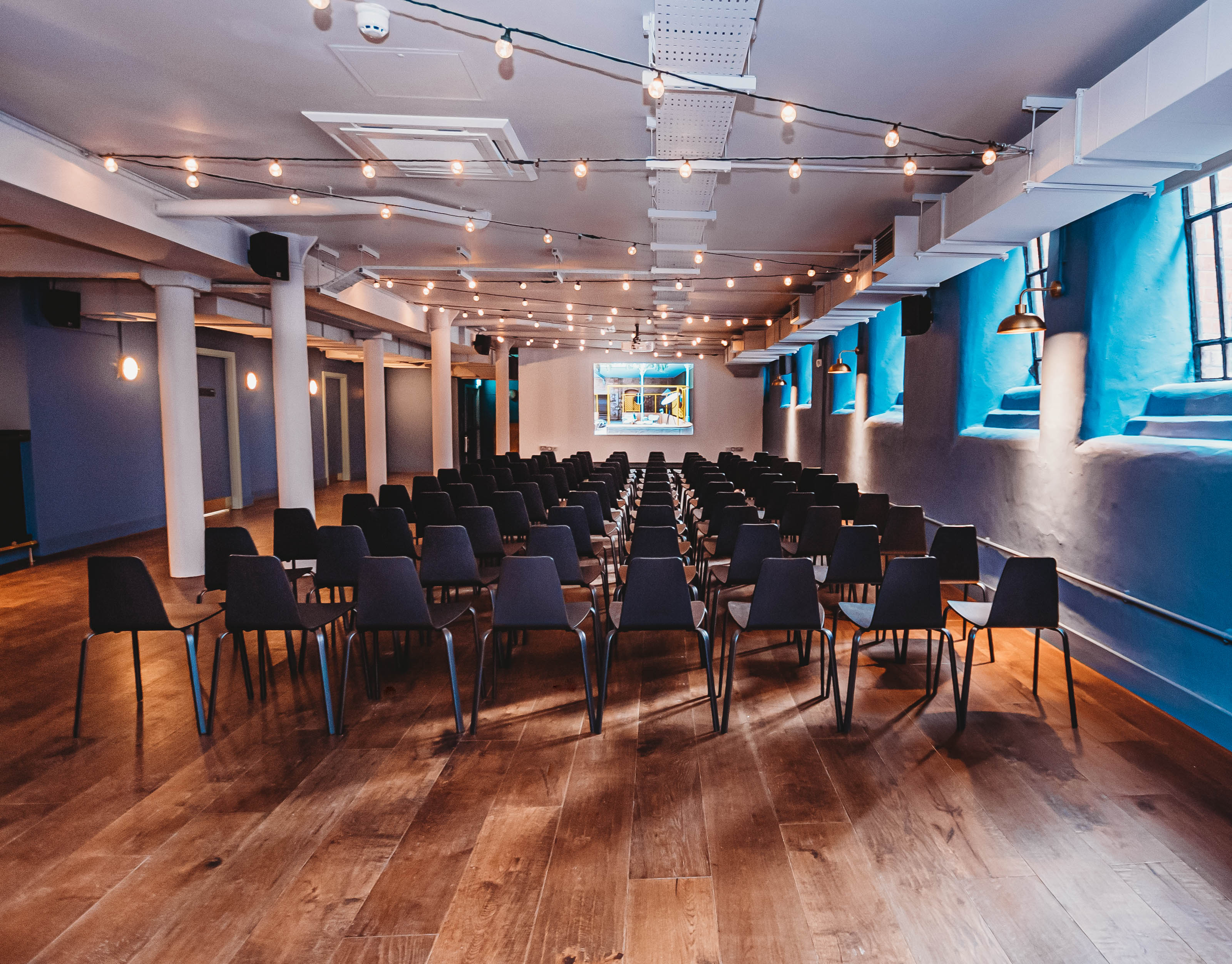 Event space at The Storehouse, Whitworth Locke, with bright stage and sleek chairs.