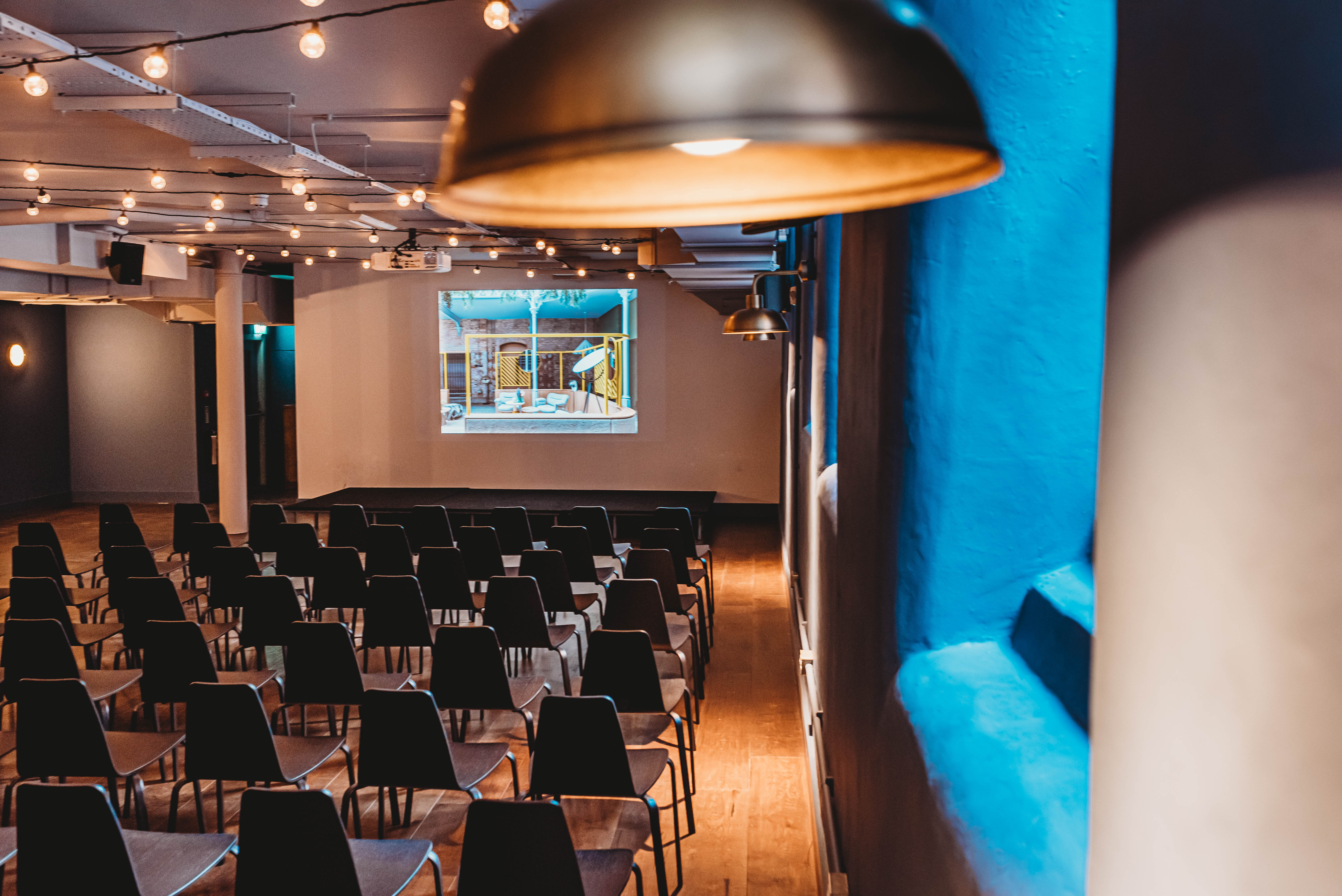 Versatile event space at The Storehouse, featuring rows of chairs and ambient lighting.