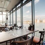 Stylish waterfront restaurant with large windows, ideal for corporate events and gatherings.