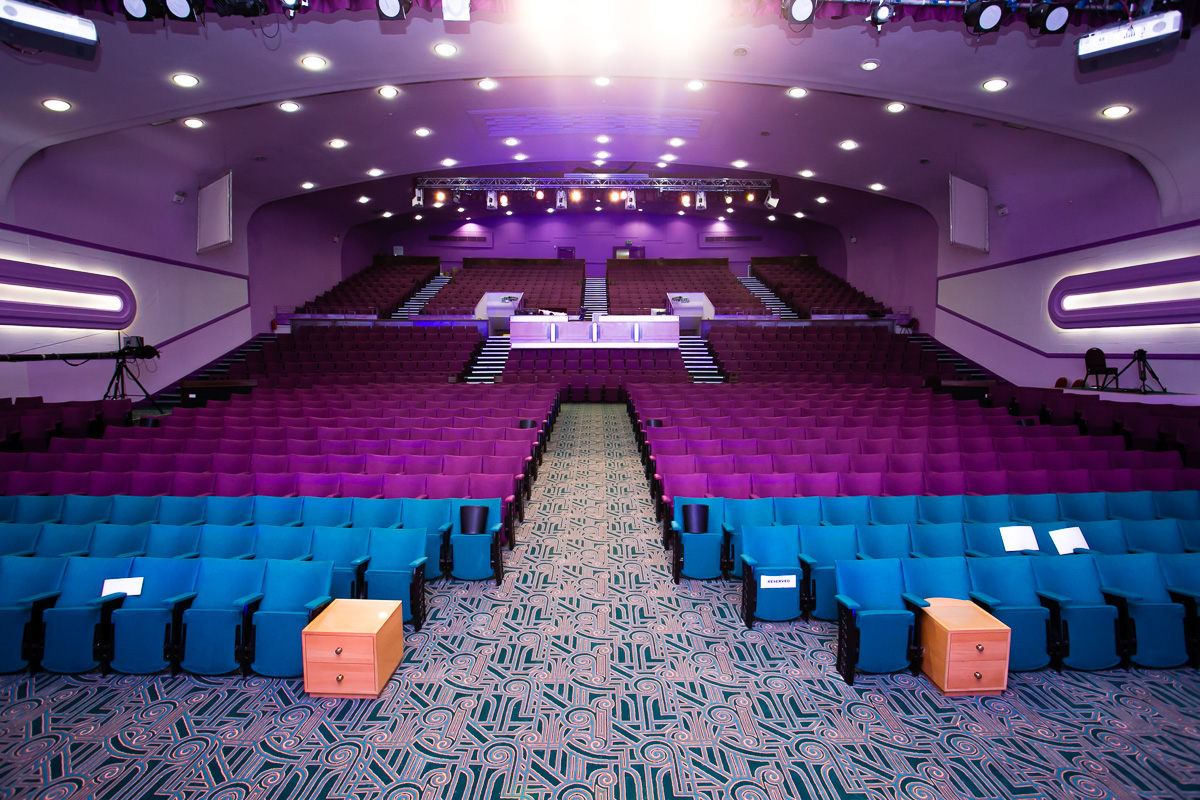 Auditorium in Gateway House with teal and purple seating, ideal for conferences and performances.