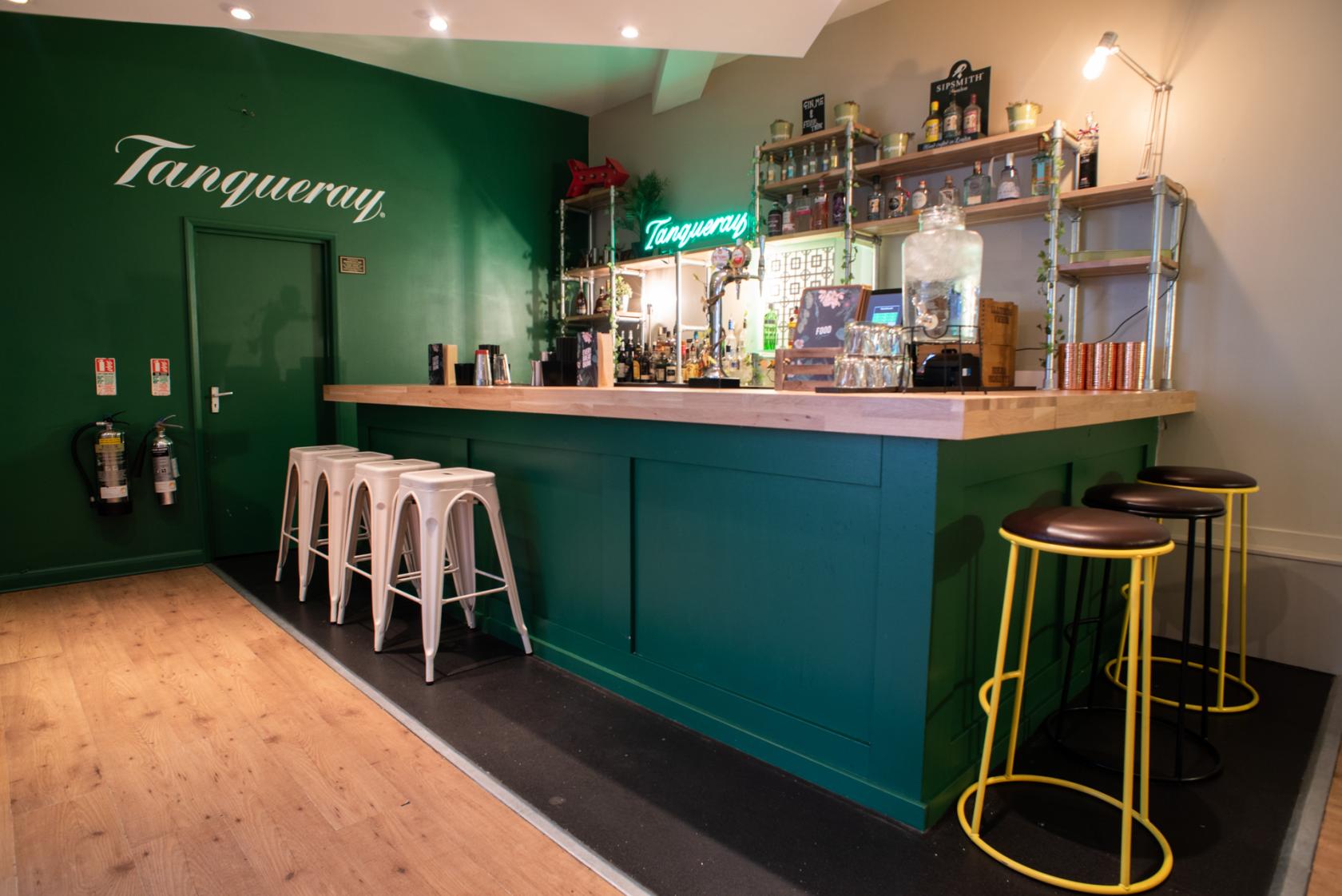Stylish bar area with green wall, ideal for networking events and cocktail receptions.