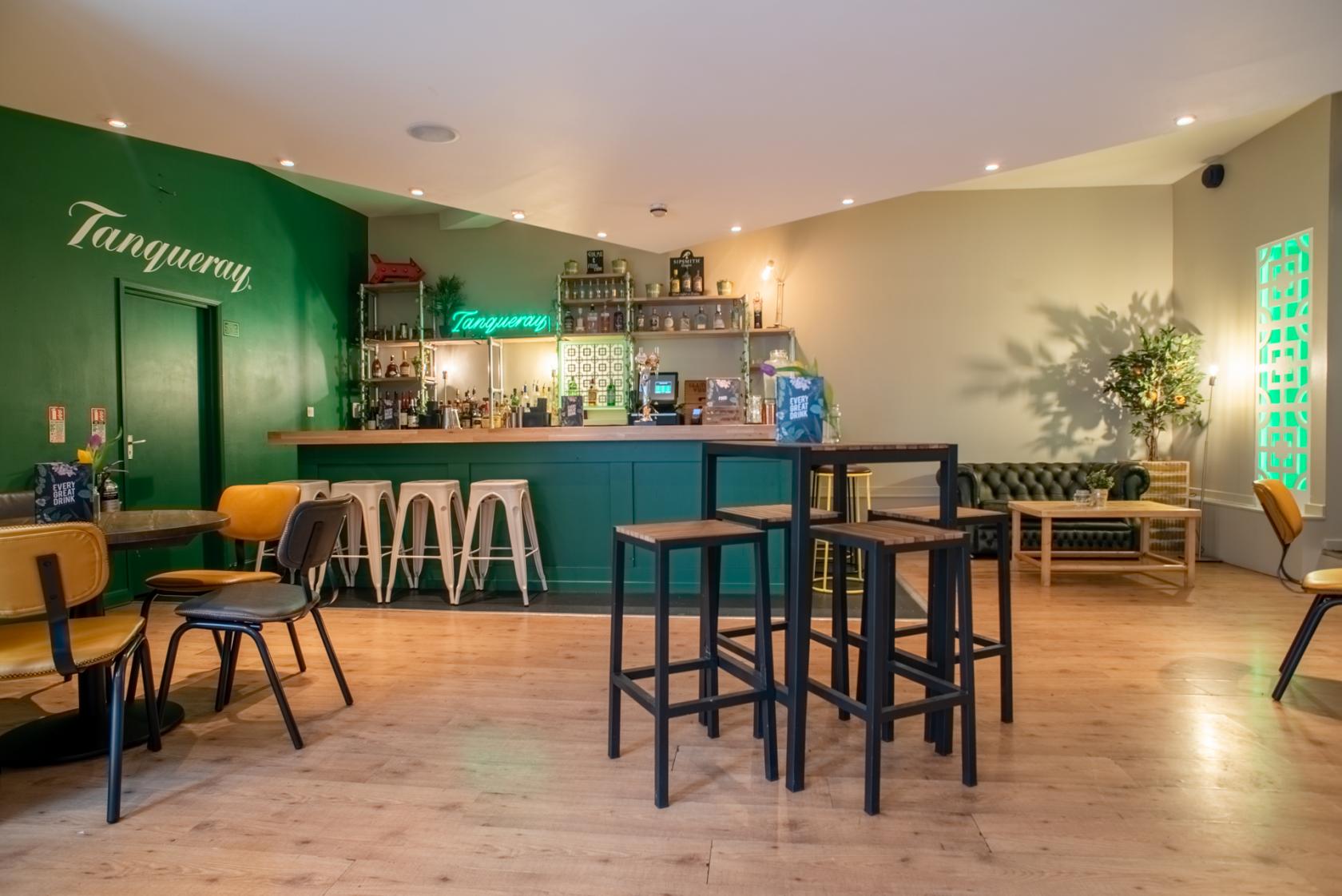 Stylish bar area with vibrant green accents, perfect for networking events and cocktail receptions.