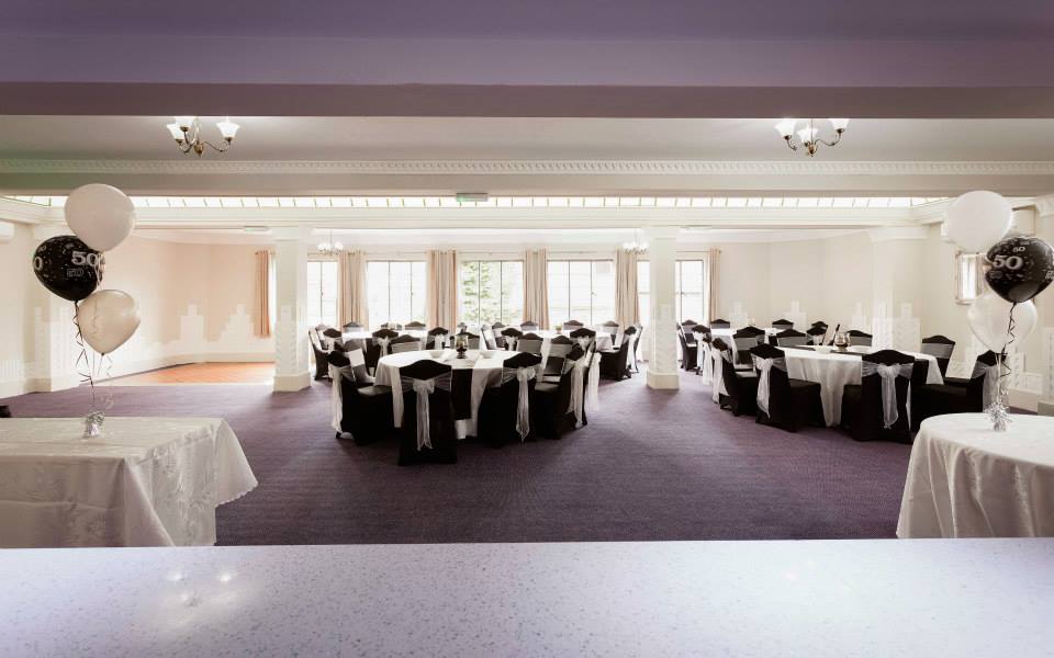 Elegant event space at Burton Ritz with round tables, perfect for celebrations and gatherings.