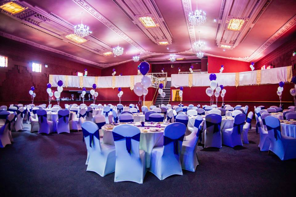 Elegant event space at Burton Ritz with round tables and blue accents for weddings or gatherings.