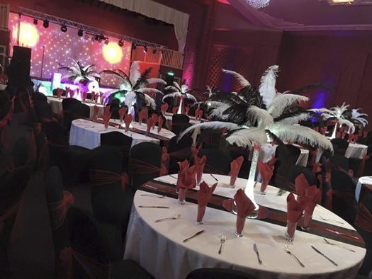 Elegant event space at Burton Ritz with feather centerpieces for gala gatherings.