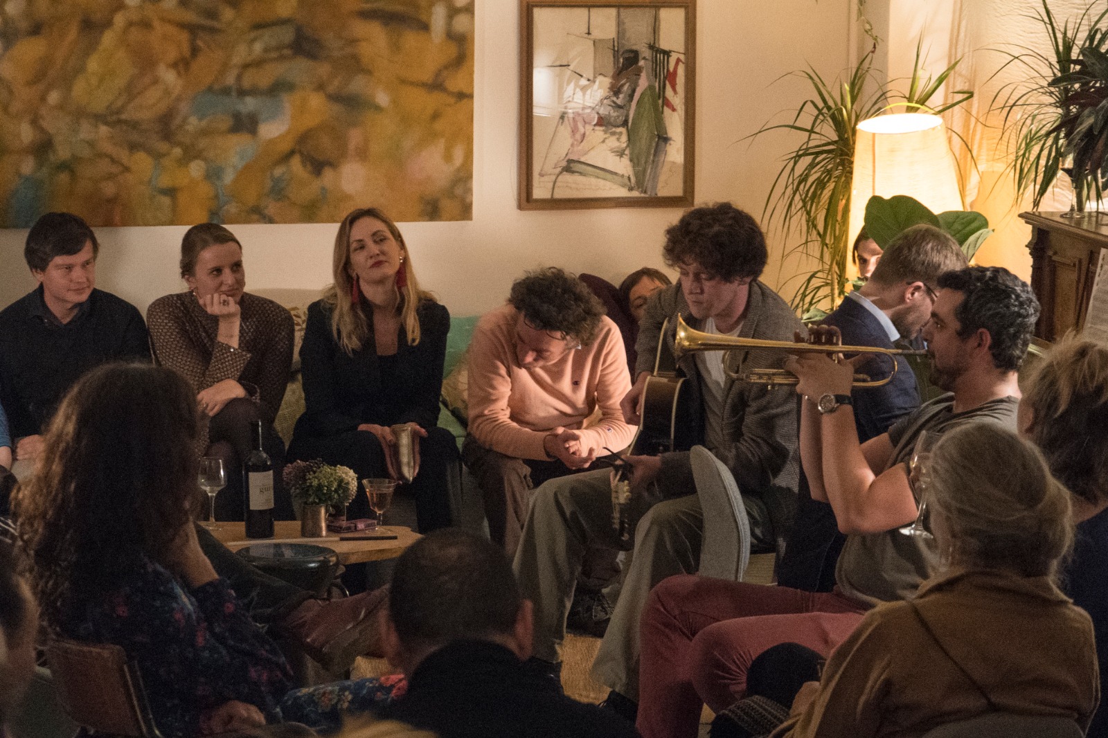 Intimate networking event in a cozy studio with soft lighting and live music.