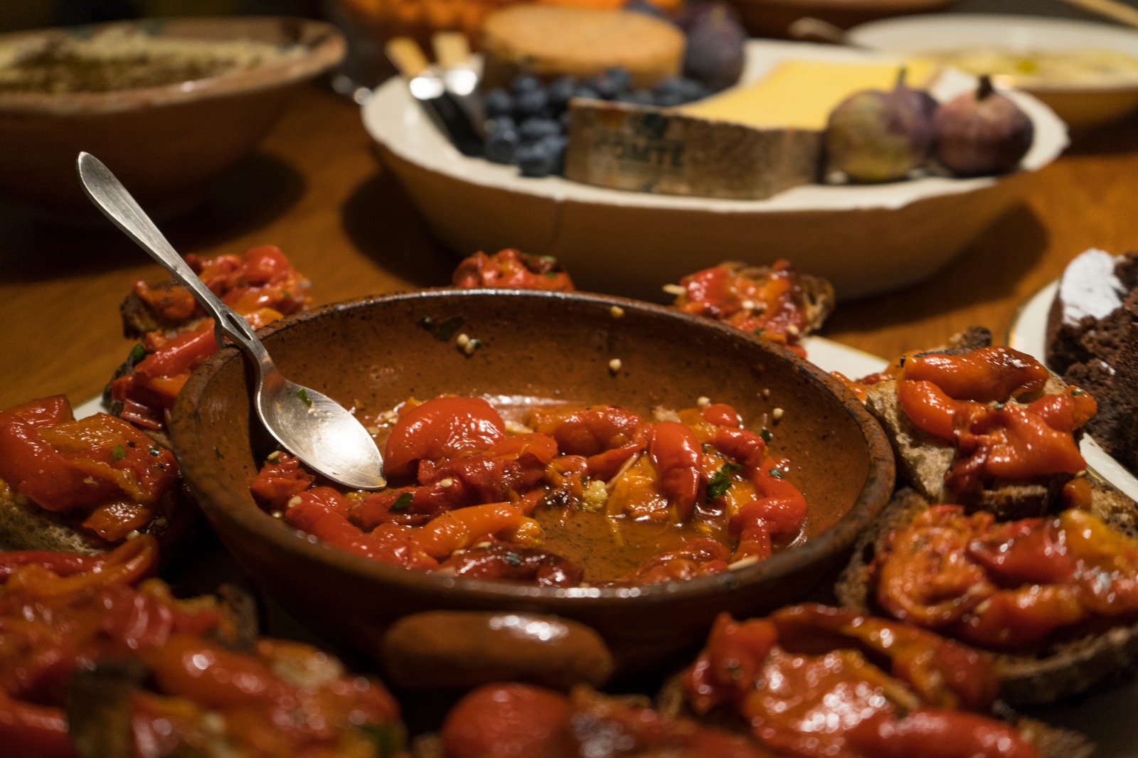 Rustic dishes with roasted peppers in a cozy studio for culinary events and gatherings.