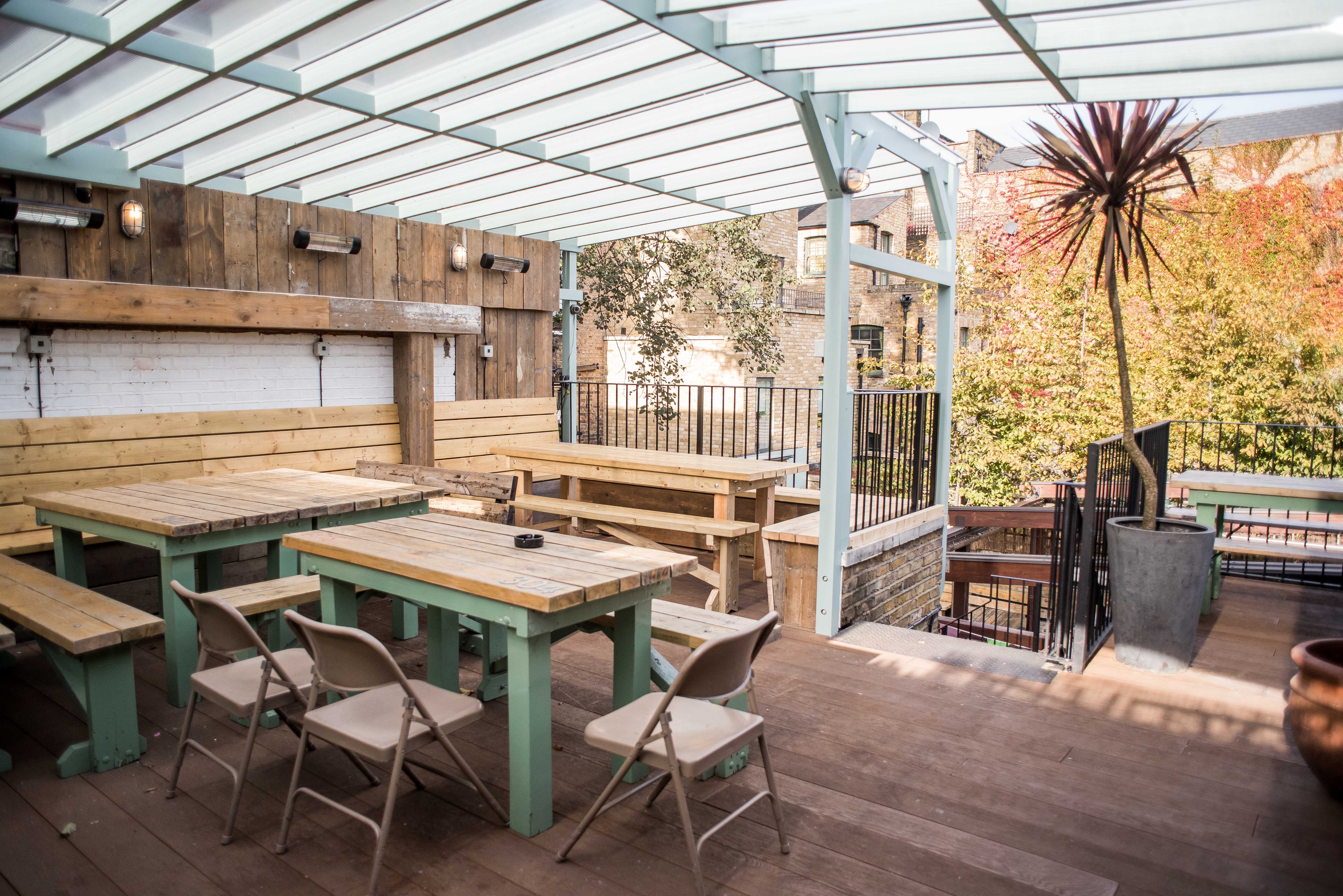 Outdoor event space at Abbey Tavern with wooden tables, ideal for networking and gatherings.