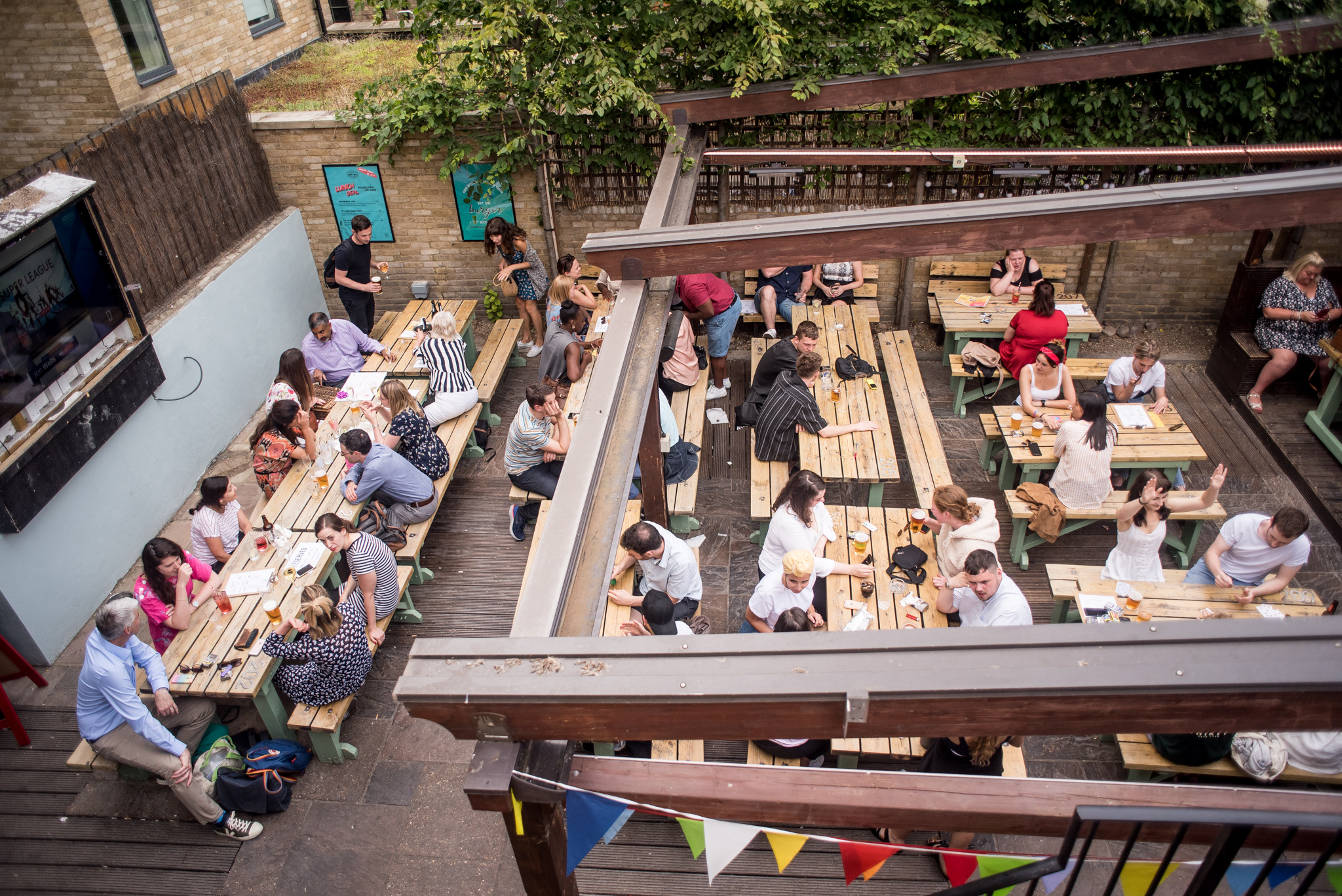 Vibrant outdoor event space at Abbey Tavern with communal tables for networking.