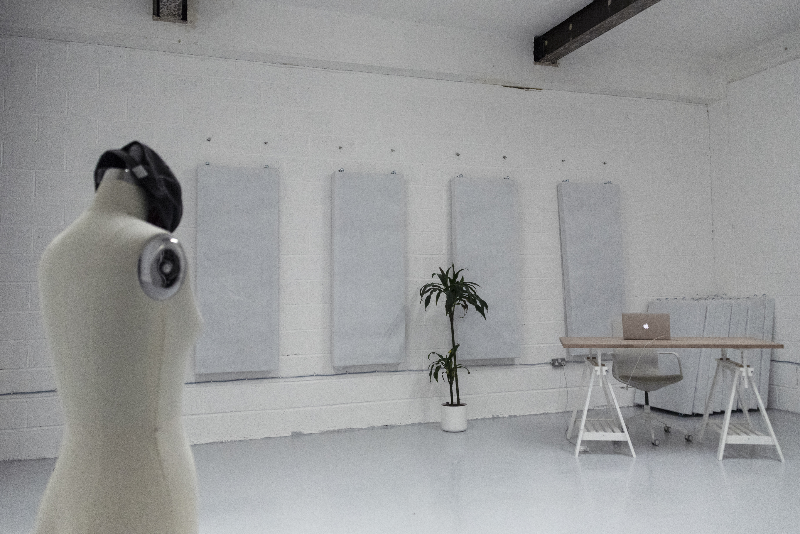 Minimalist event space with mannequin and laptop, perfect for meetings and workshops.