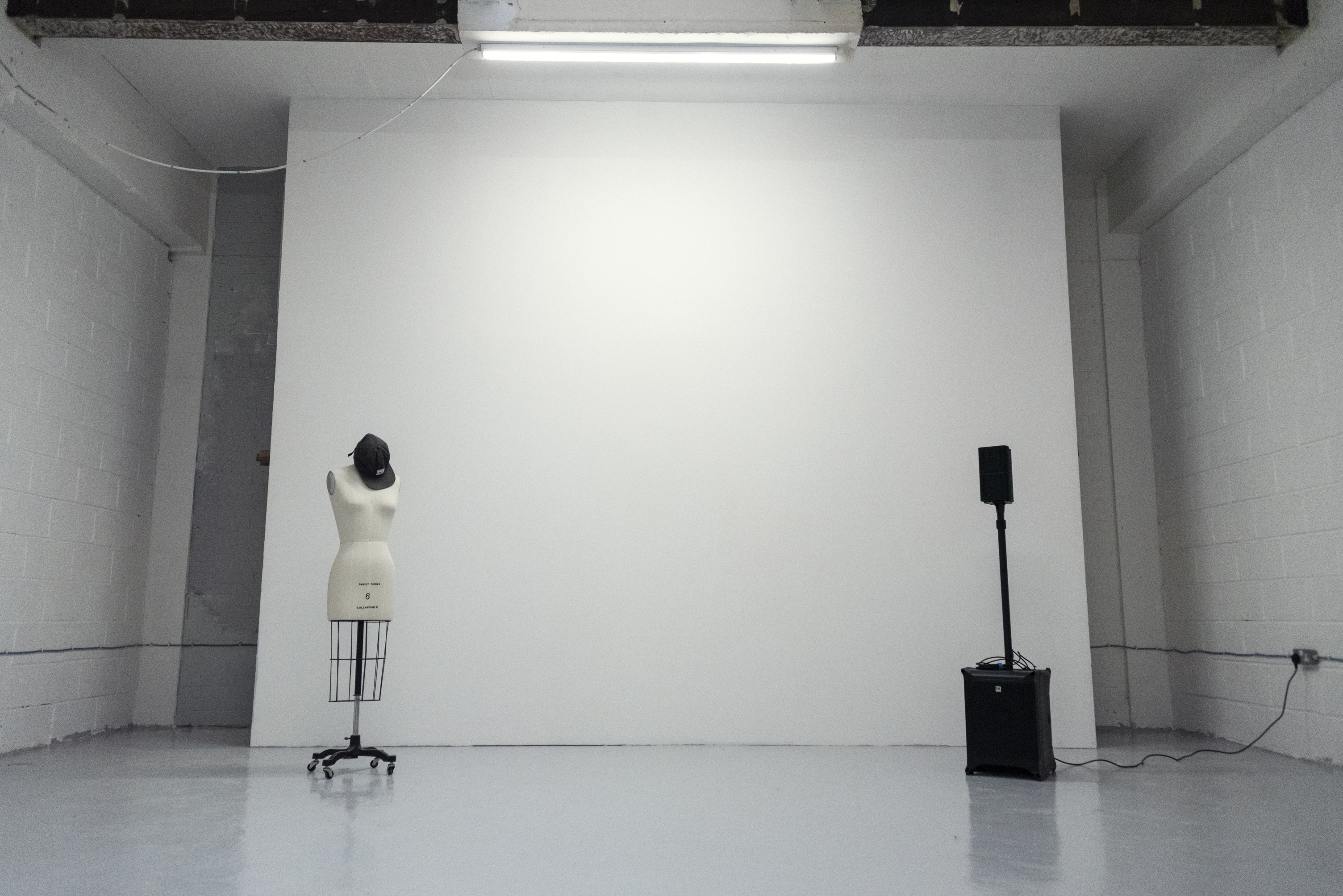 Minimalist event space in Grow Studios with blank wall for branding and fashion showcases.