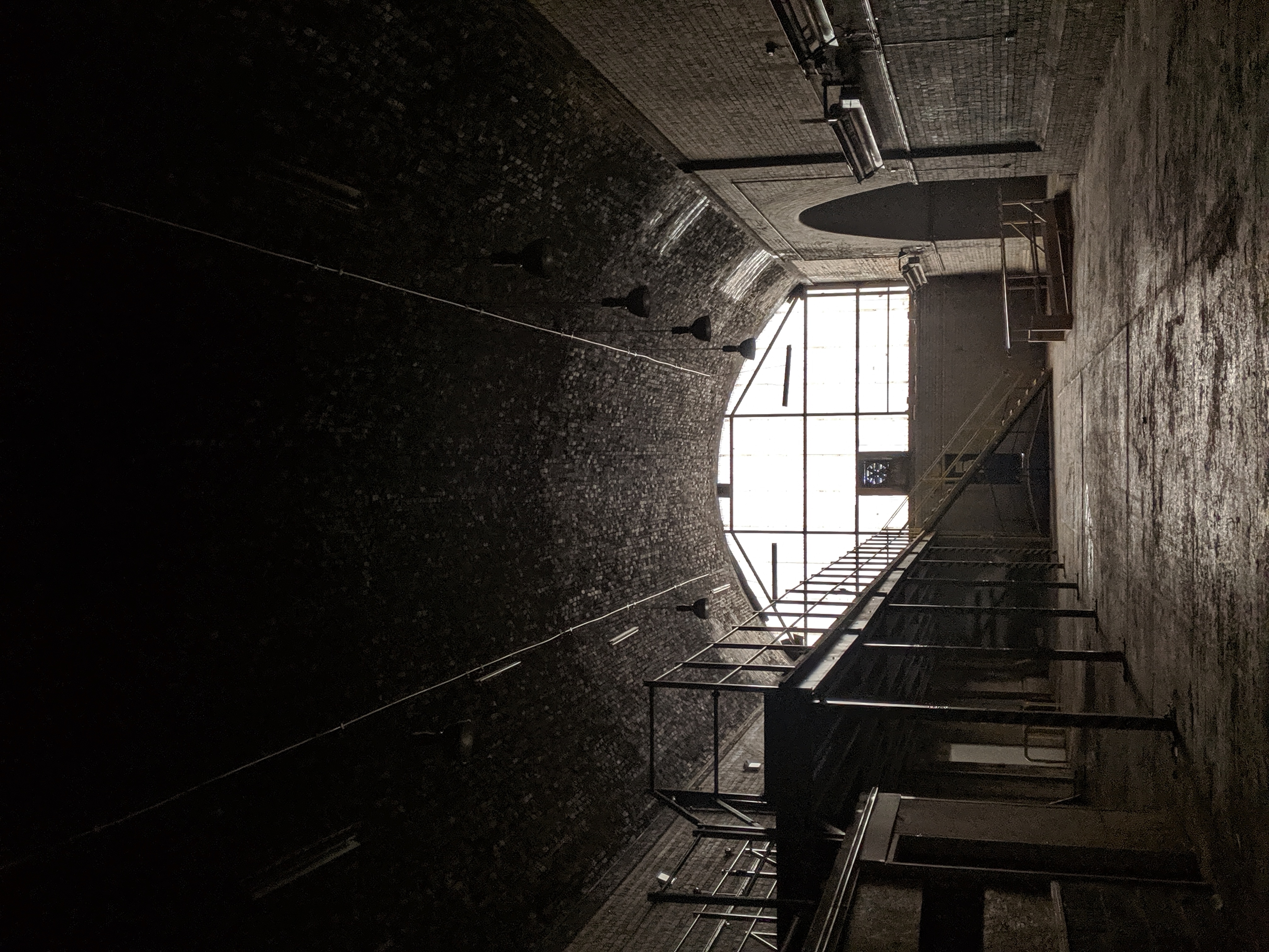 Spacious industrial venue with arched ceiling, perfect for creative events and gatherings.