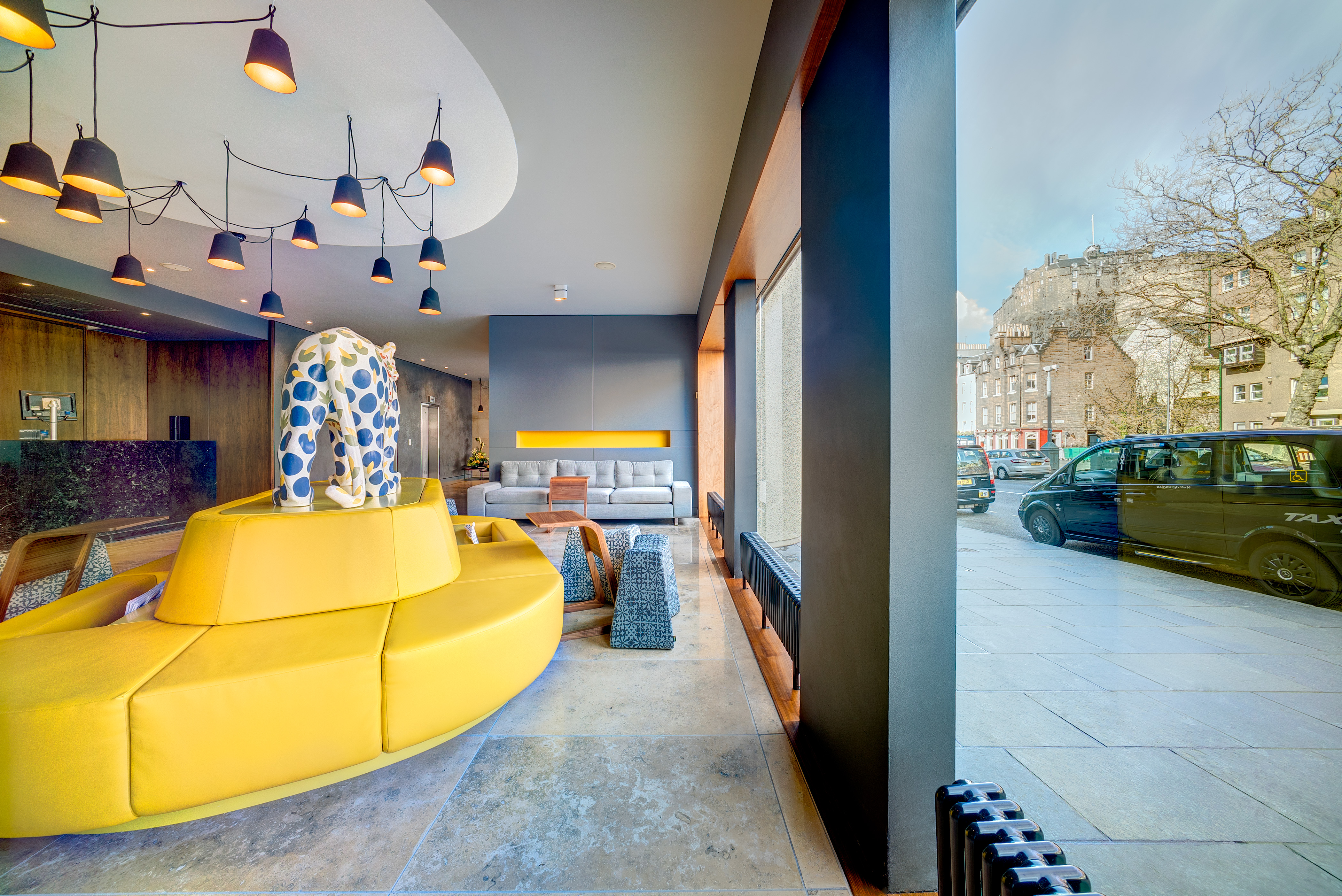 Agua Restaurant lobby with vibrant yellow seating for meetings and events in Edinburgh.
