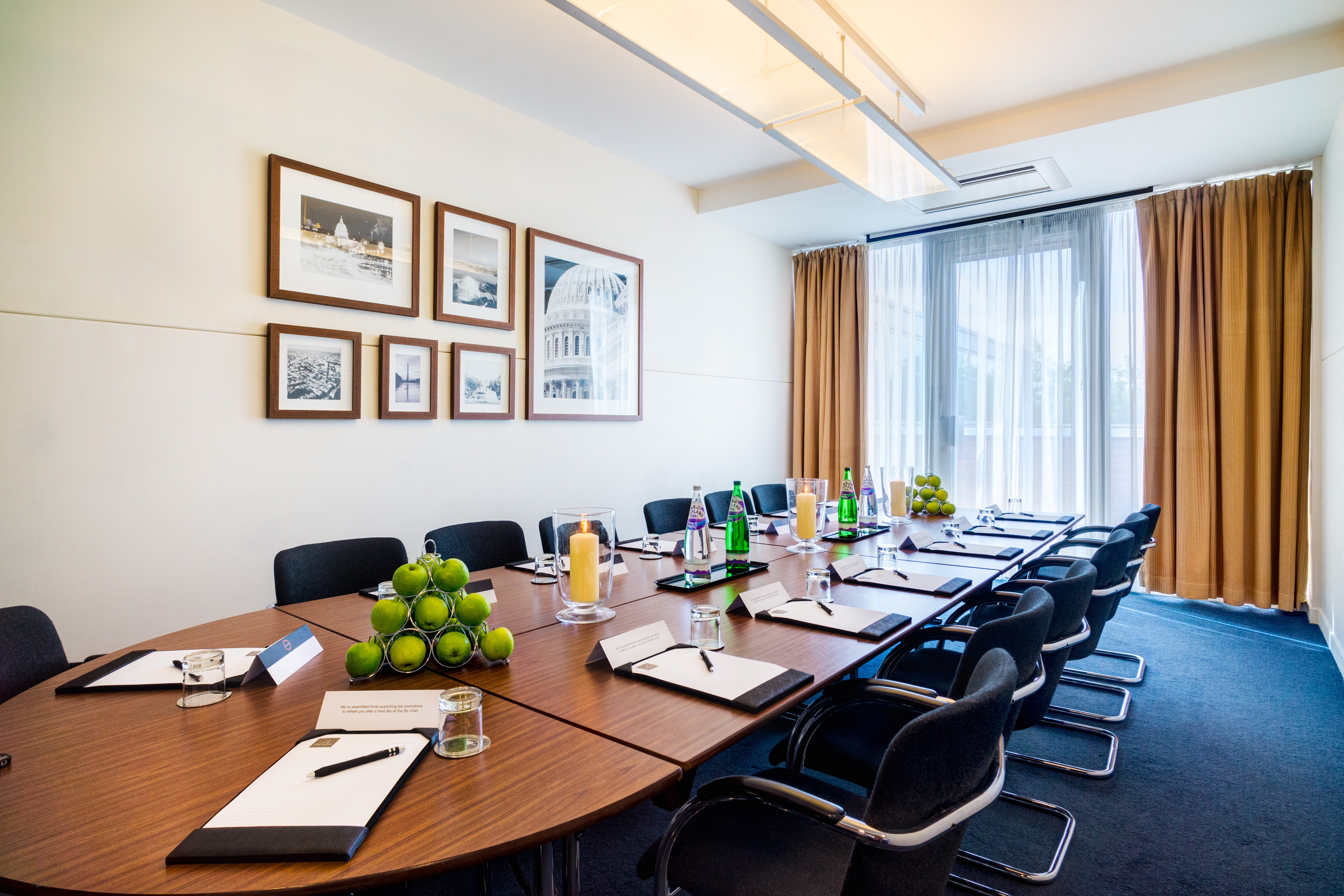 Meeting room with round table and natural light for corporate events in Apex City Quay Hotel.