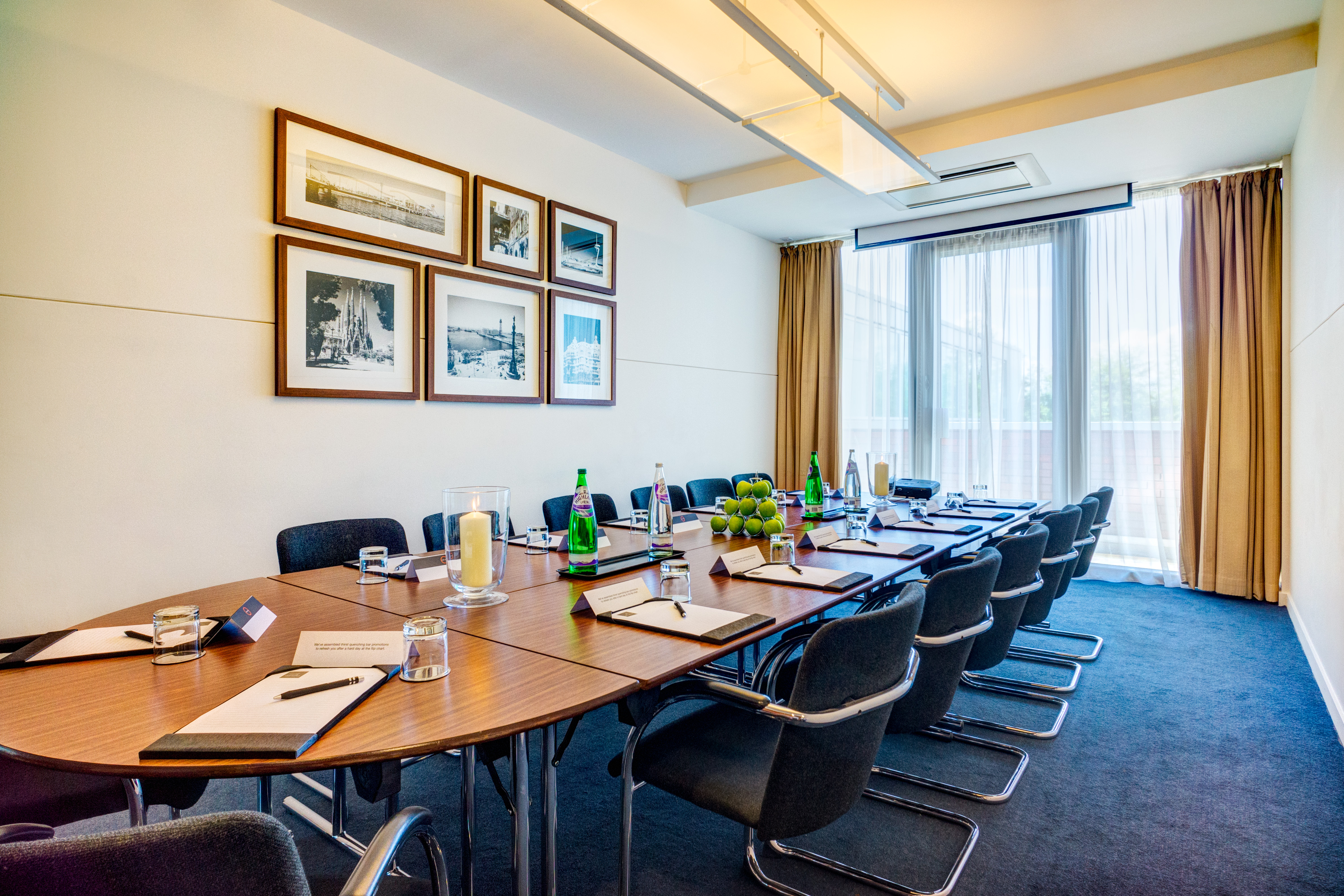 Meeting room with oval table, natural light, ideal for corporate events and gatherings.