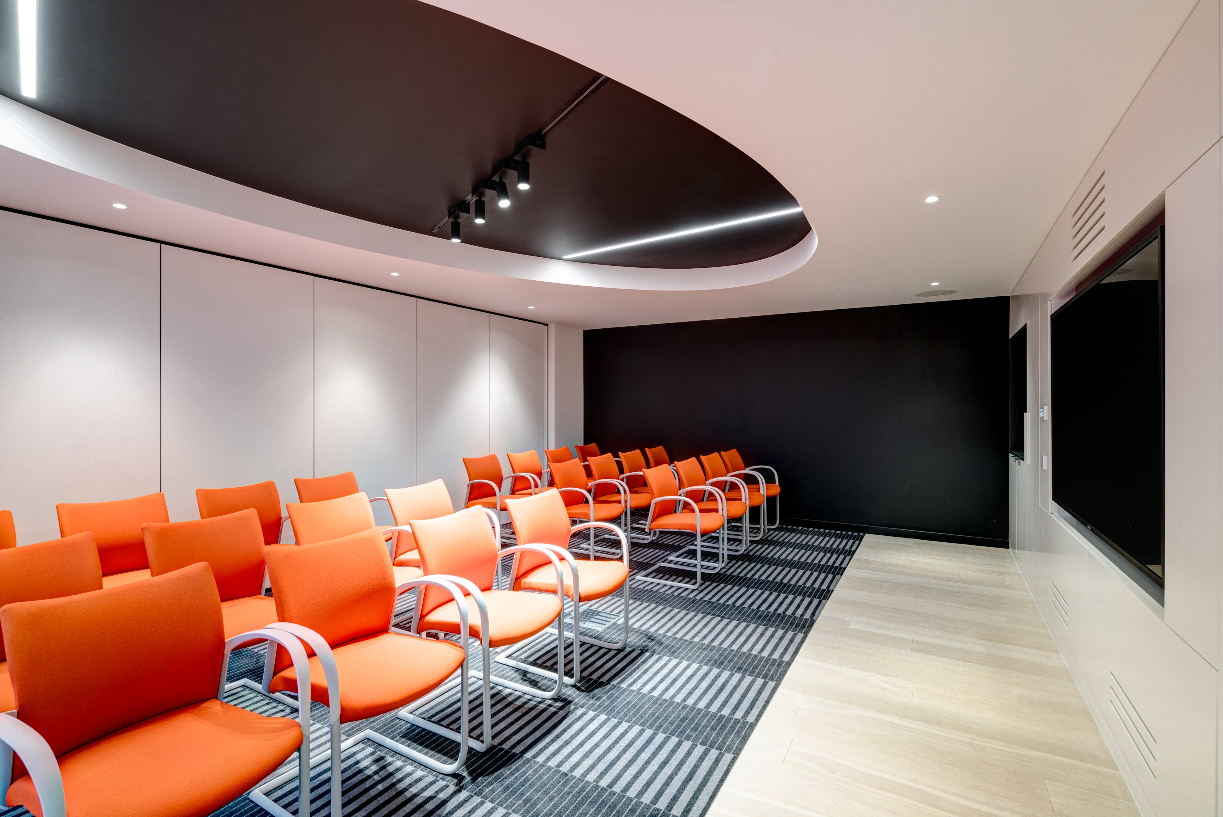 Modern meeting room at Apex City of Bath Hotel with vibrant orange chairs for events.