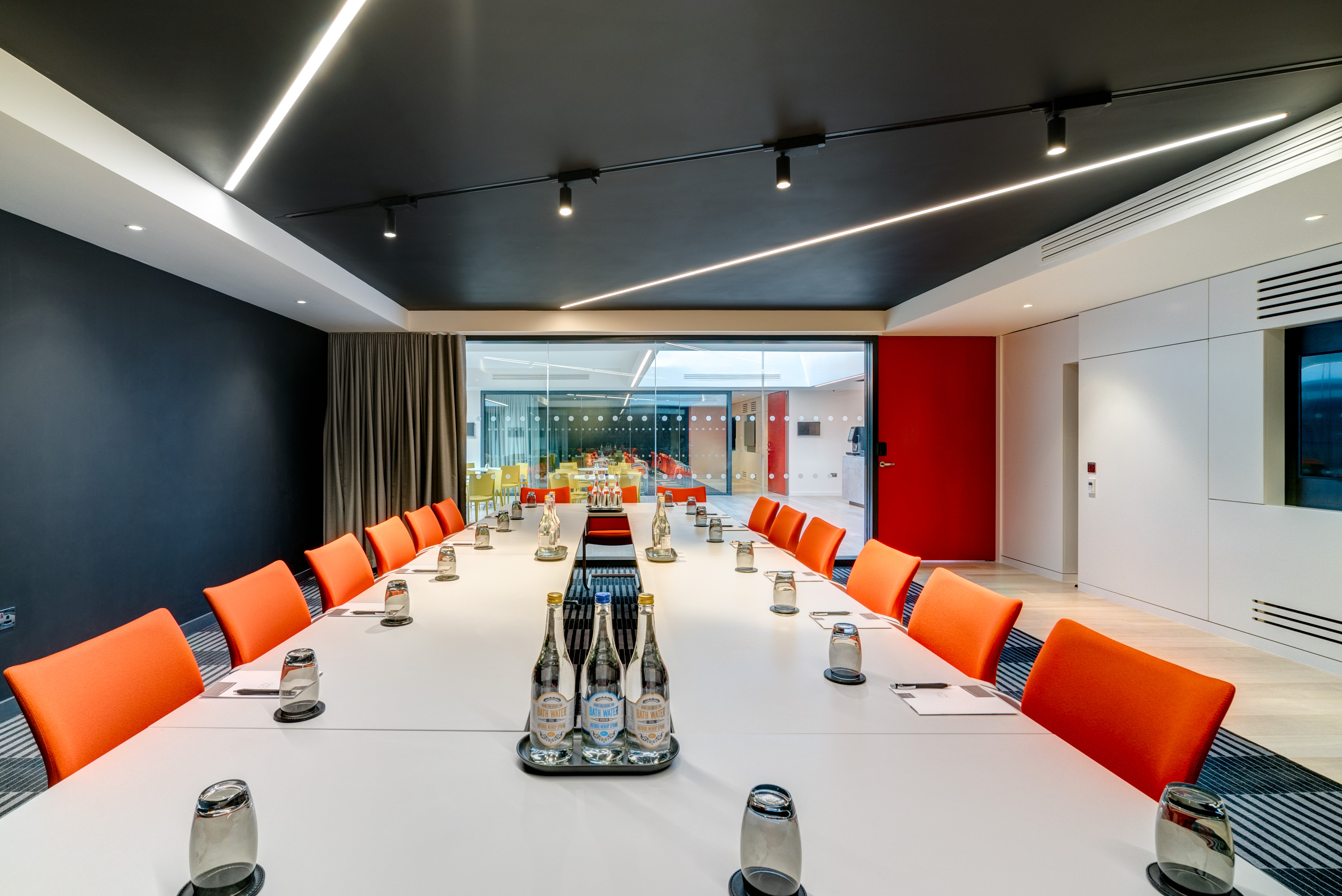 Modern meeting room in Apex City of Bath Hotel with orange chairs for collaborative events.