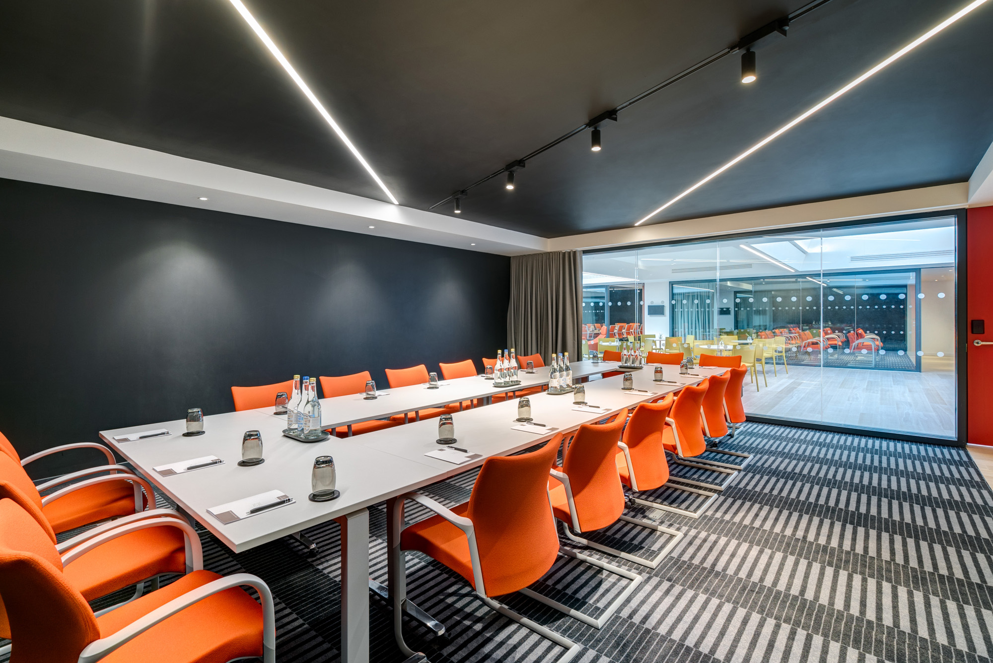 Modern meeting room in Bathwick, Apex City of Bath Hotel, with orange chairs for workshops.