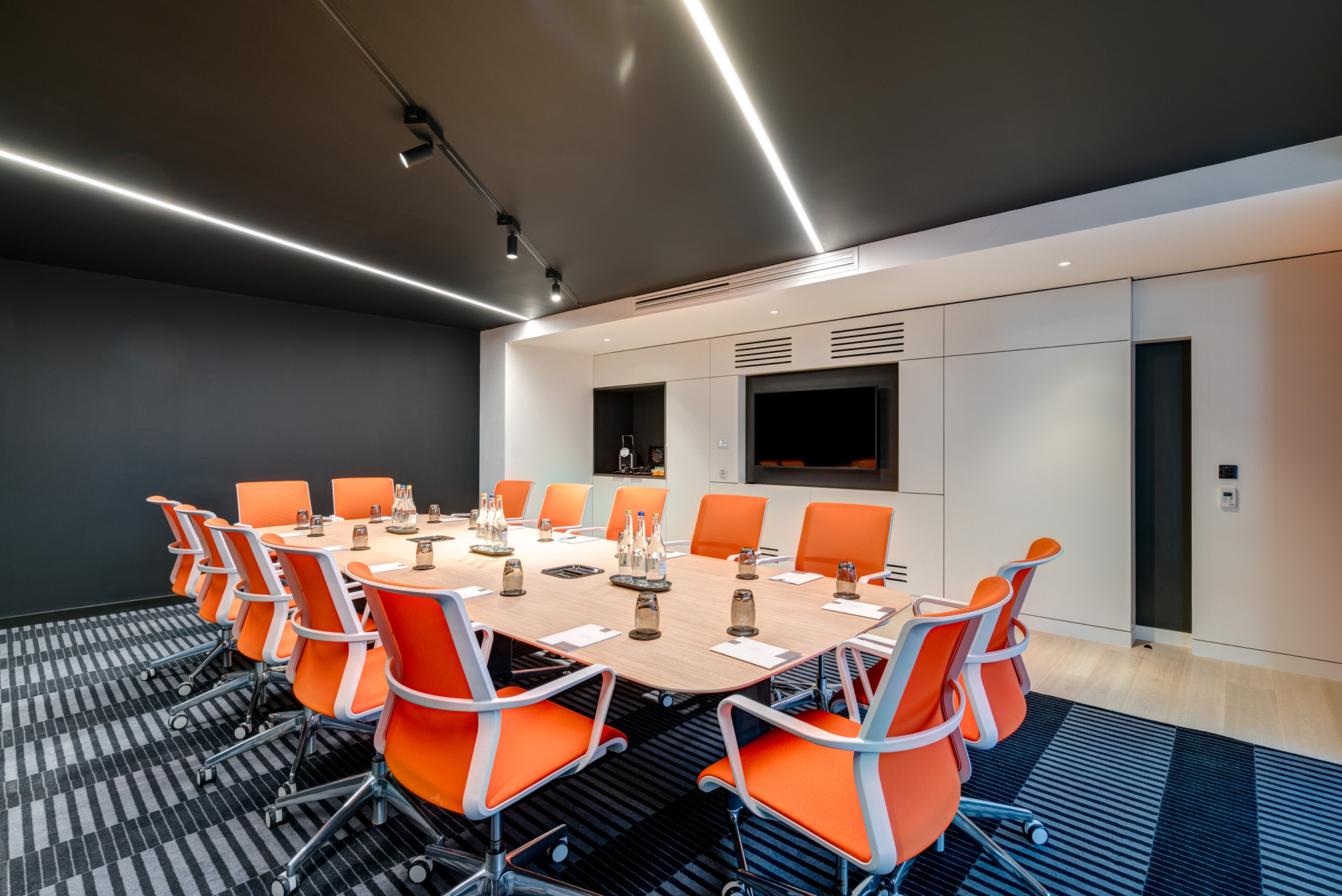 Modern conference room with oval table and ergonomic chairs in Apex City of Bath Hotel.