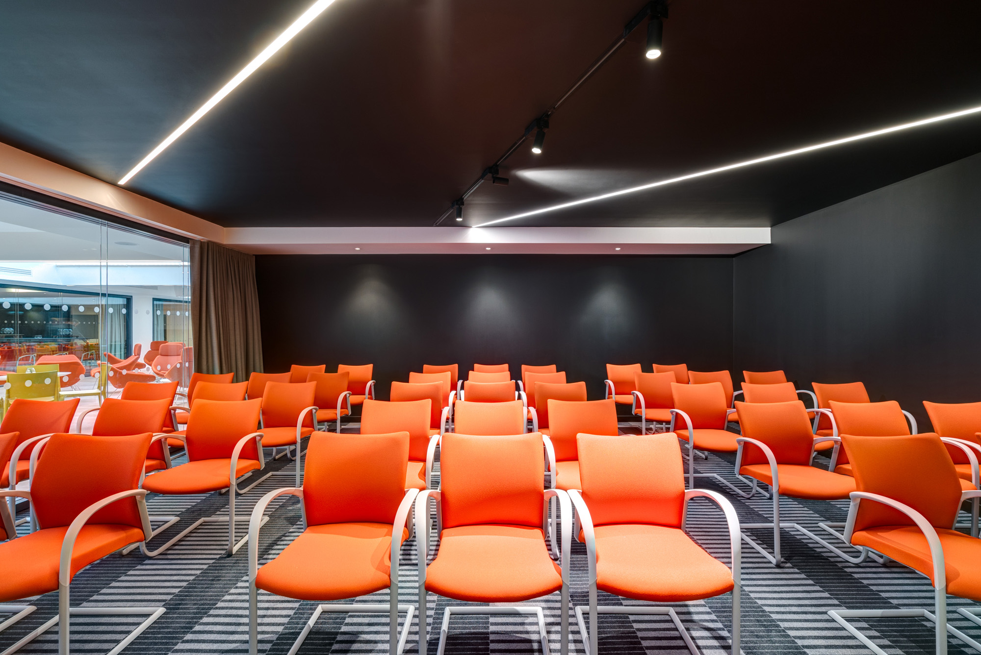 Modern meeting space at Apex City of Bath Hotel with vibrant orange chairs for workshops.
