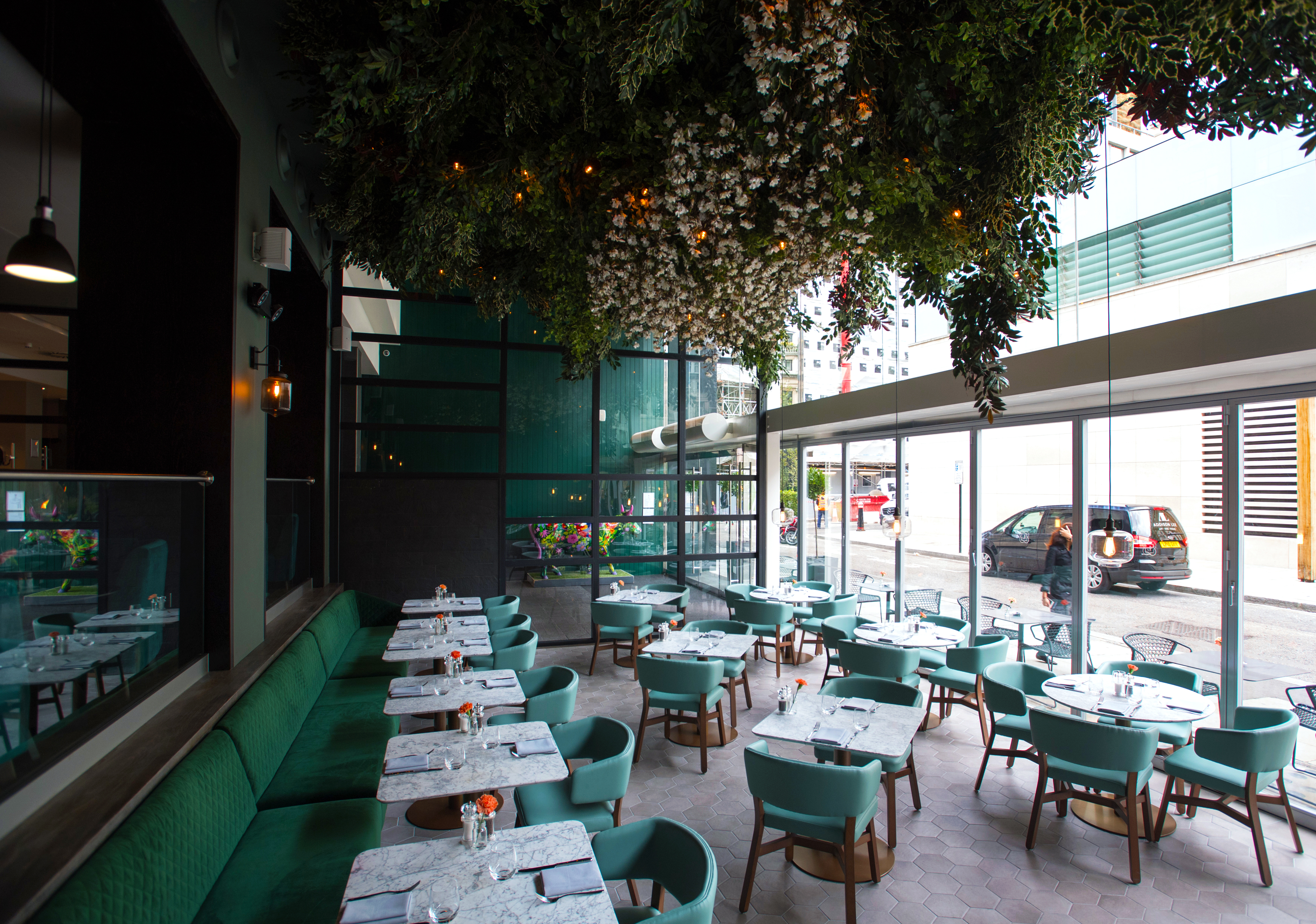 Stylish event space at The Lampery, featuring marble tables and lush greenery in London.