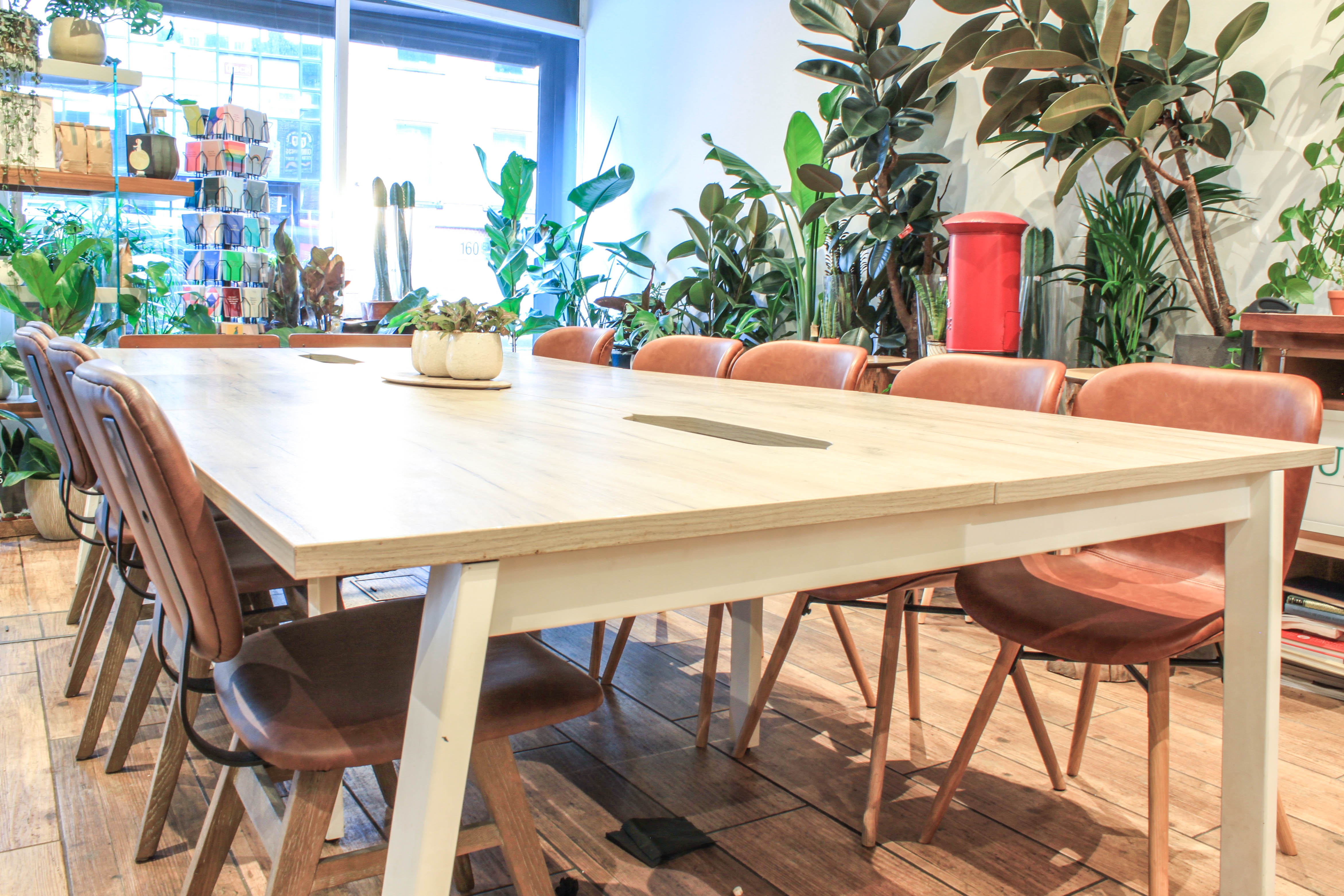 Modern meeting room with wooden table and leather chairs, perfect for workshops and team meetings.