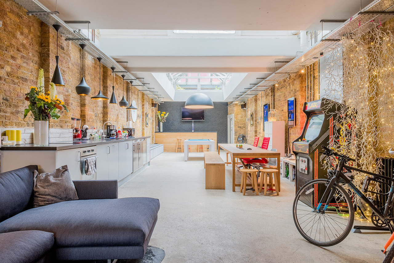 Co-sharing studio with exposed brick, ideal for creative workshops and casual meetings.