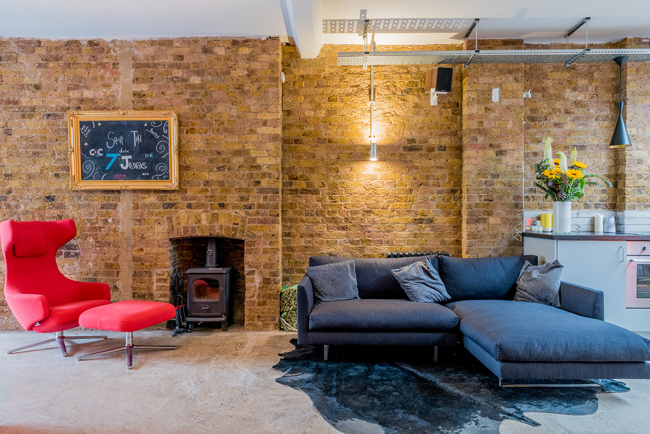 Co-sharing studio meeting space with modern furniture and warm brick wall for creative collaboration.