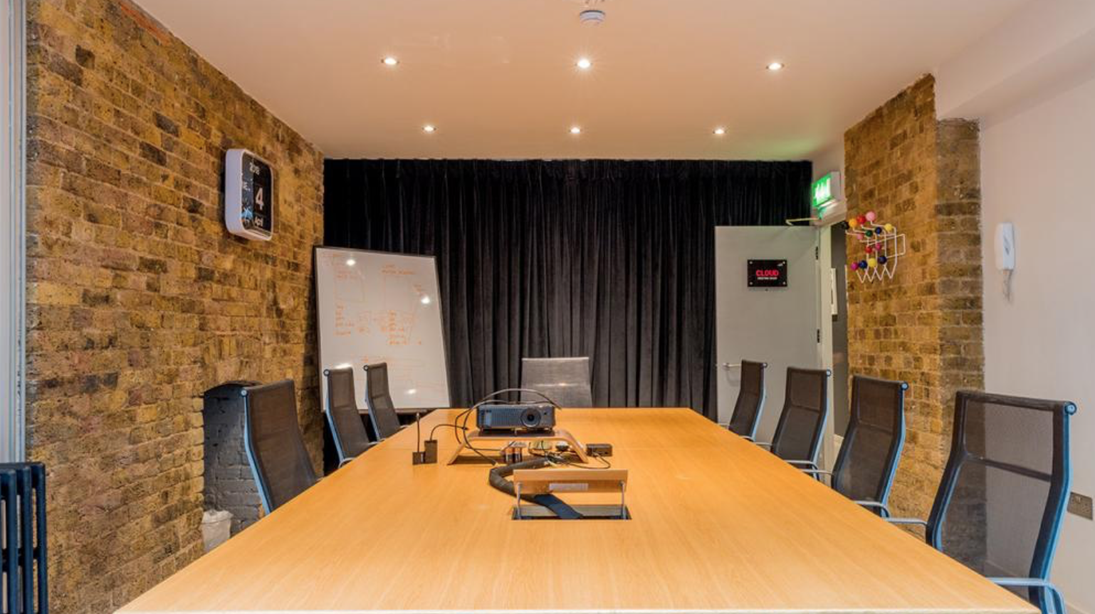 Modern conference room with wooden table, projector, and brick walls for effective meetings.