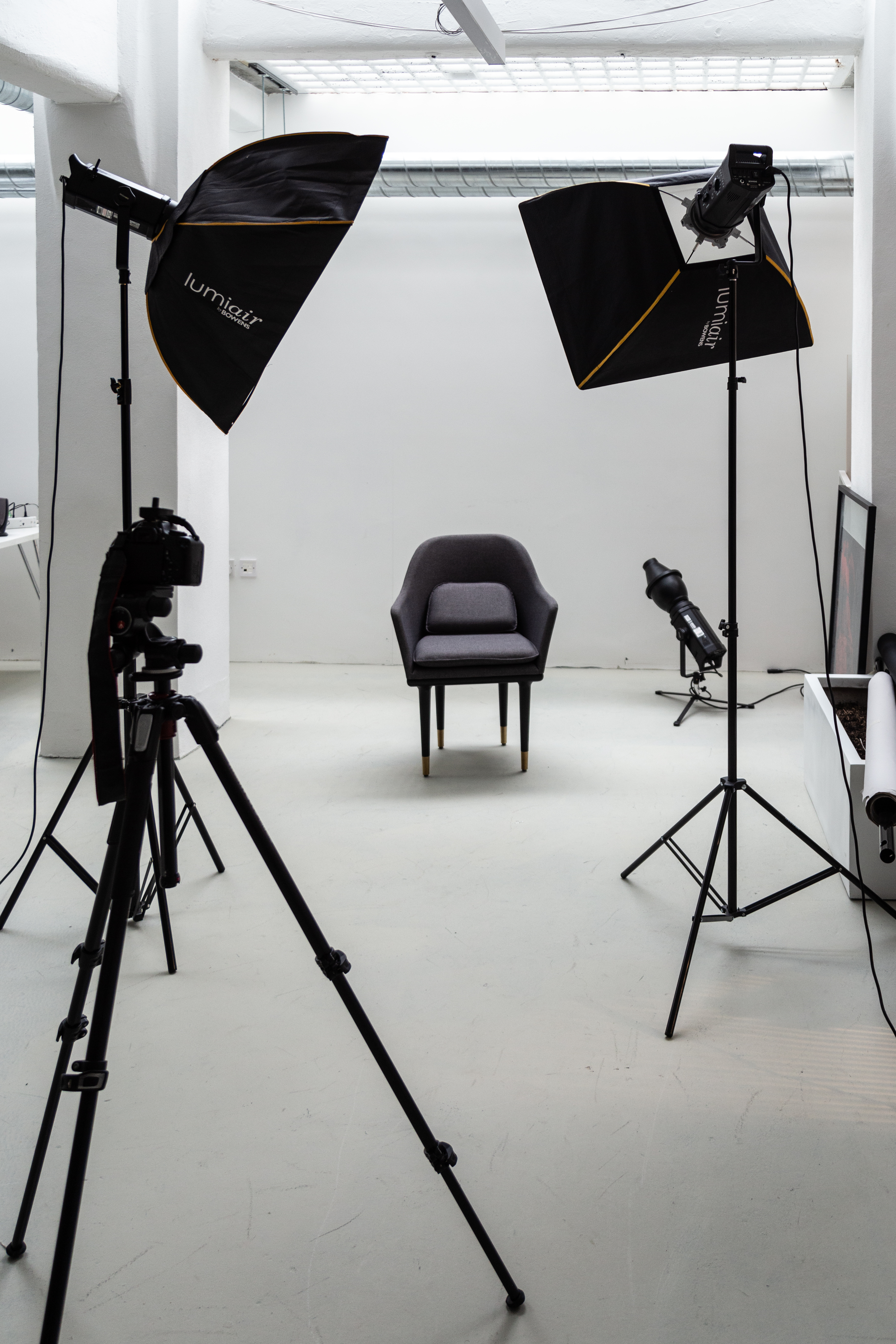 Minimalist interview setup in contemporary photography studio with single chair and professional lighting.