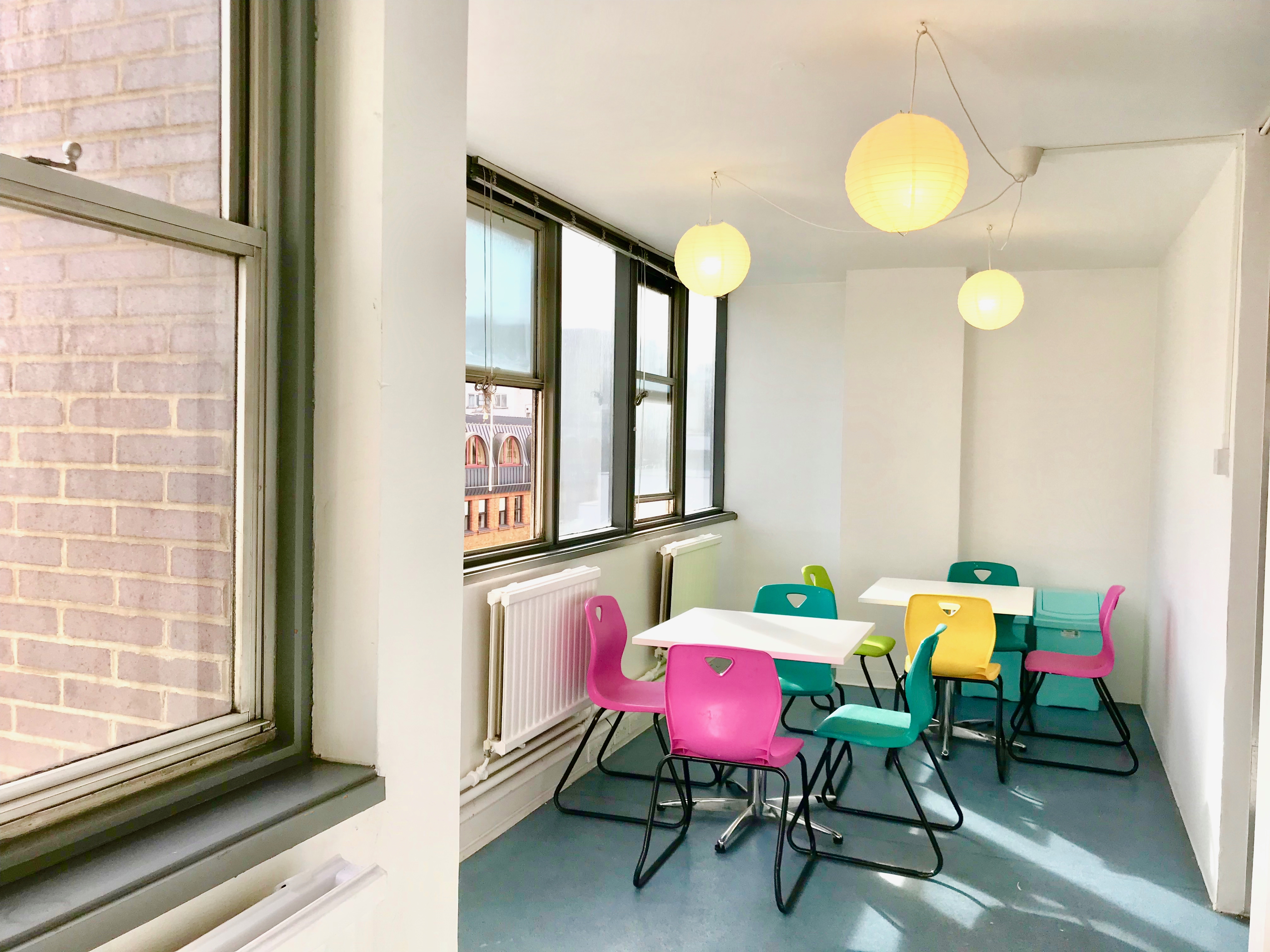 Bright meeting space with colorful chairs at Day Hire Studio, ideal for workshops and gatherings.