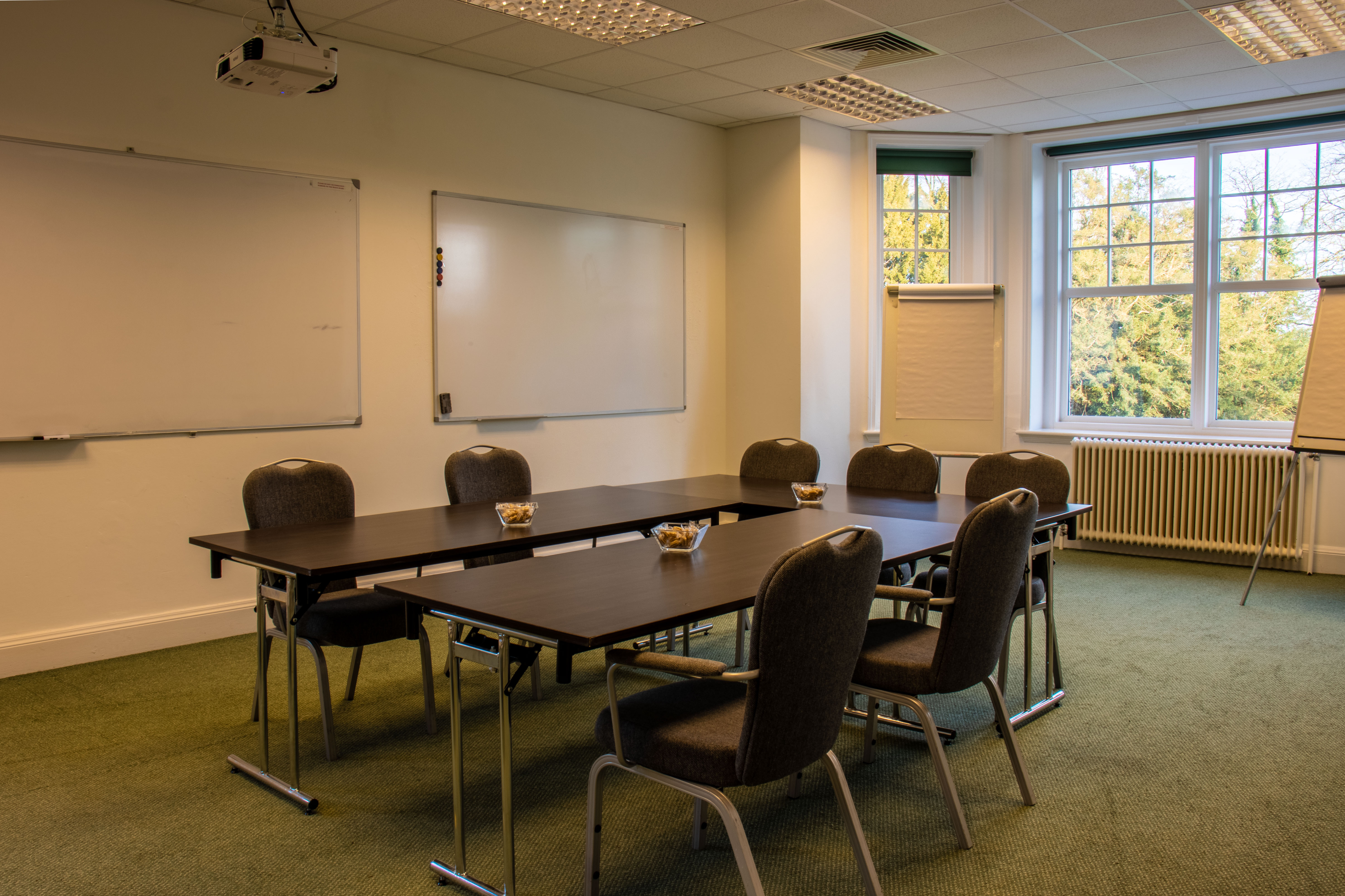 Sir John Baker in a bright meeting room with central table, ideal for collaborative events.