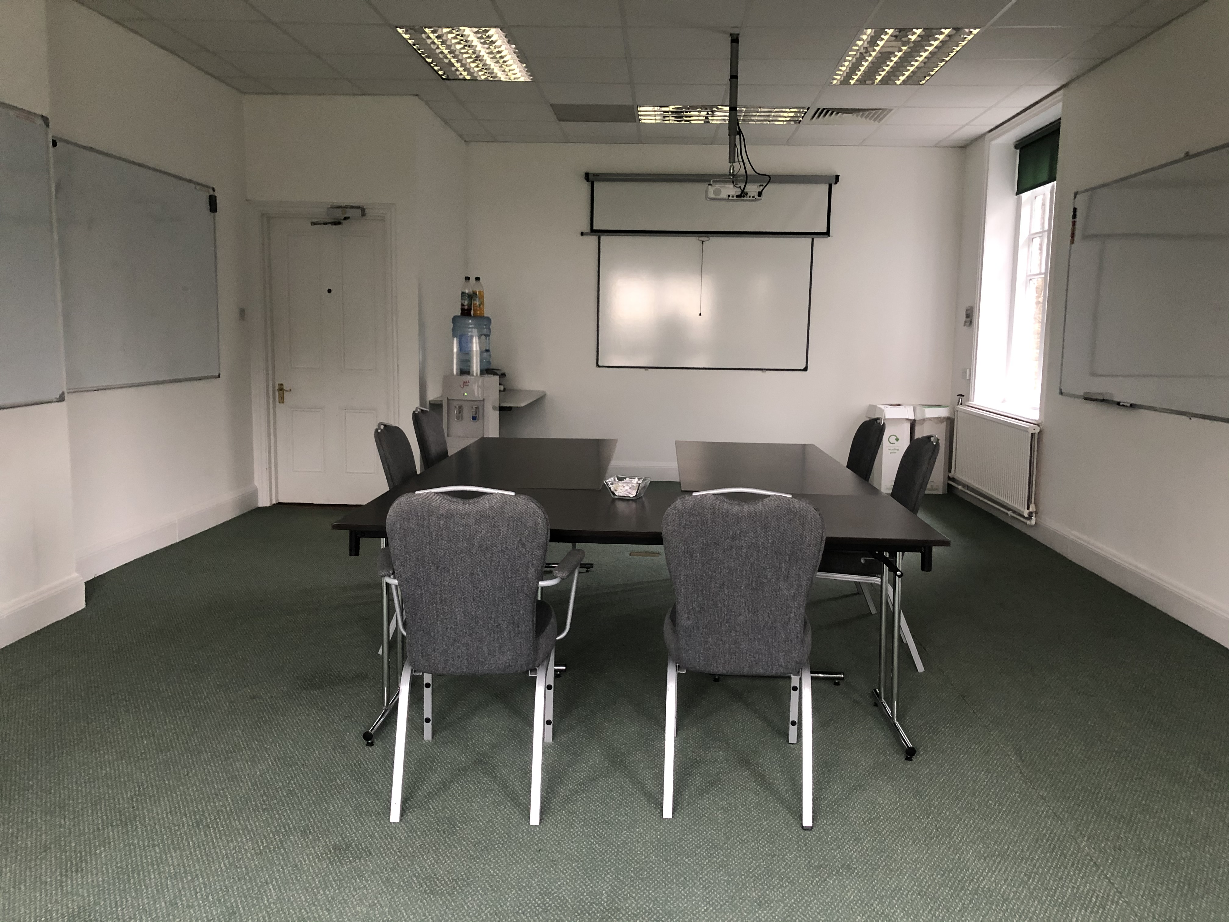 Sir John Baker in a minimalist meeting room, ideal for collaborative events and presentations.