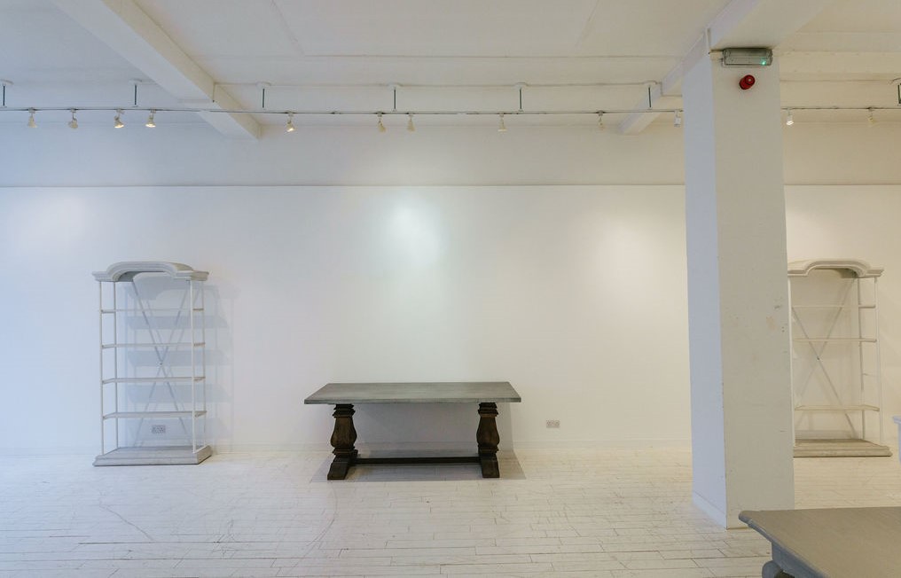 Minimalist event space at 725 Fulham Road, featuring central table & flexible lighting.