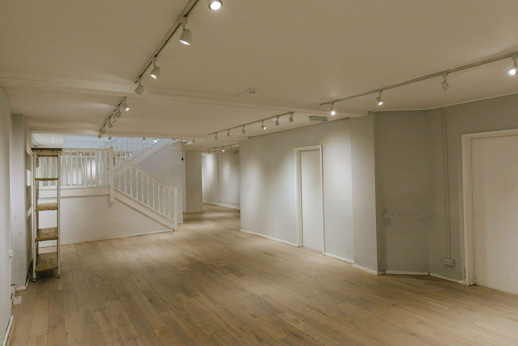 Versatile basement event space with natural light, perfect for meetings and workshops.