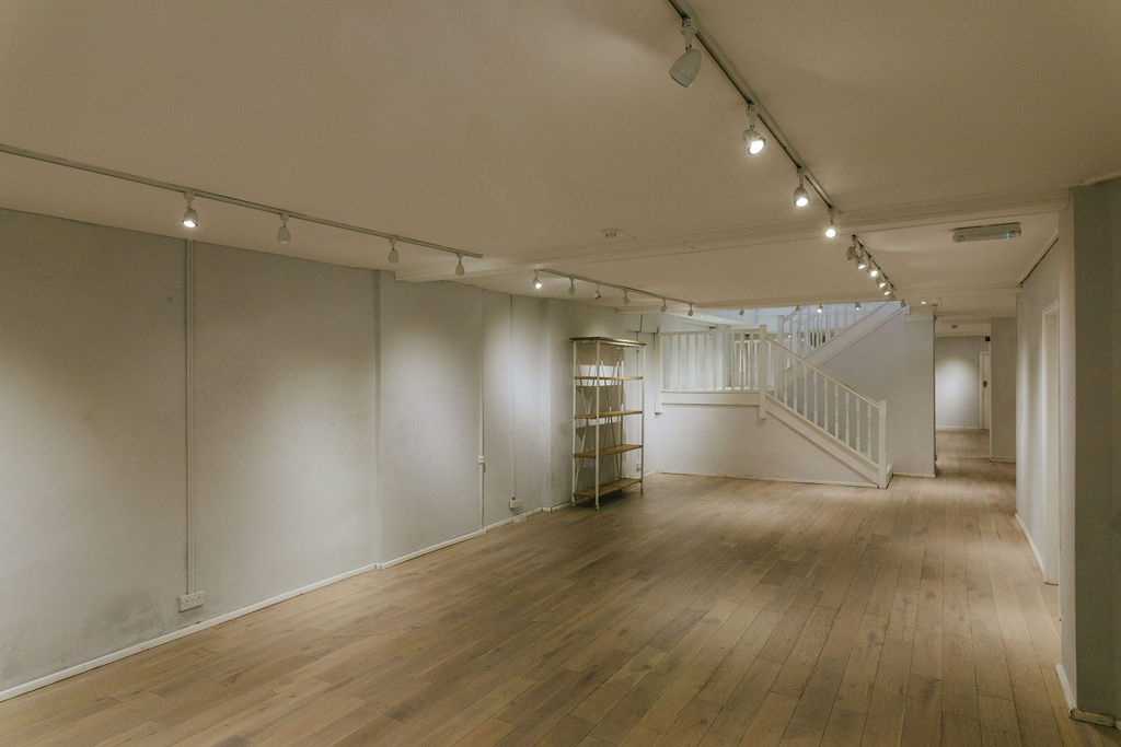 Well-lit minimalist event space with wooden flooring for networking and workshops.