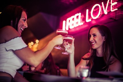 Women toasting cocktails in vibrant Be At One Clapham Common, perfect for networking events.