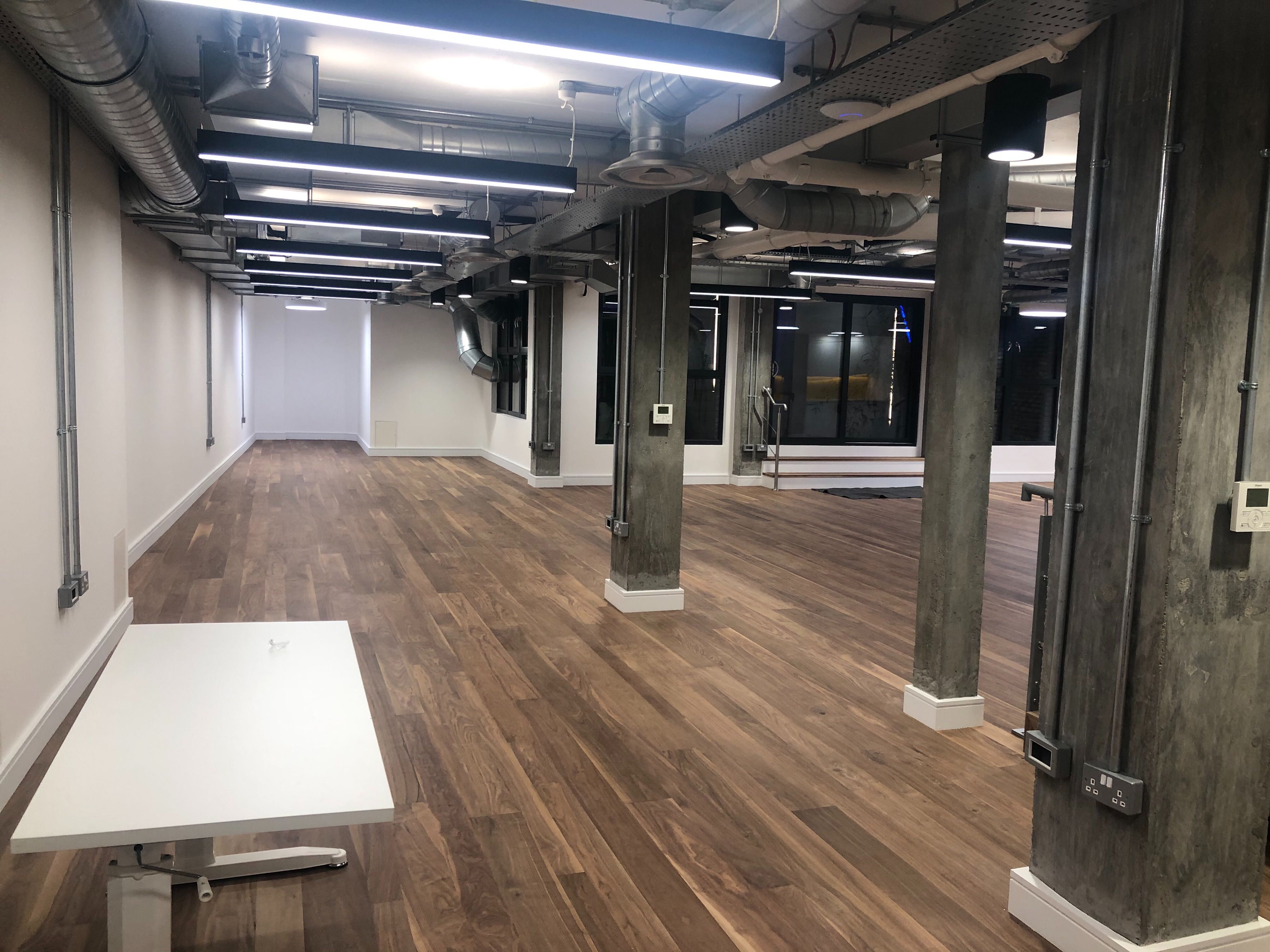 Versatile event space with polished wood floors, ideal for workshops and corporate meetings.