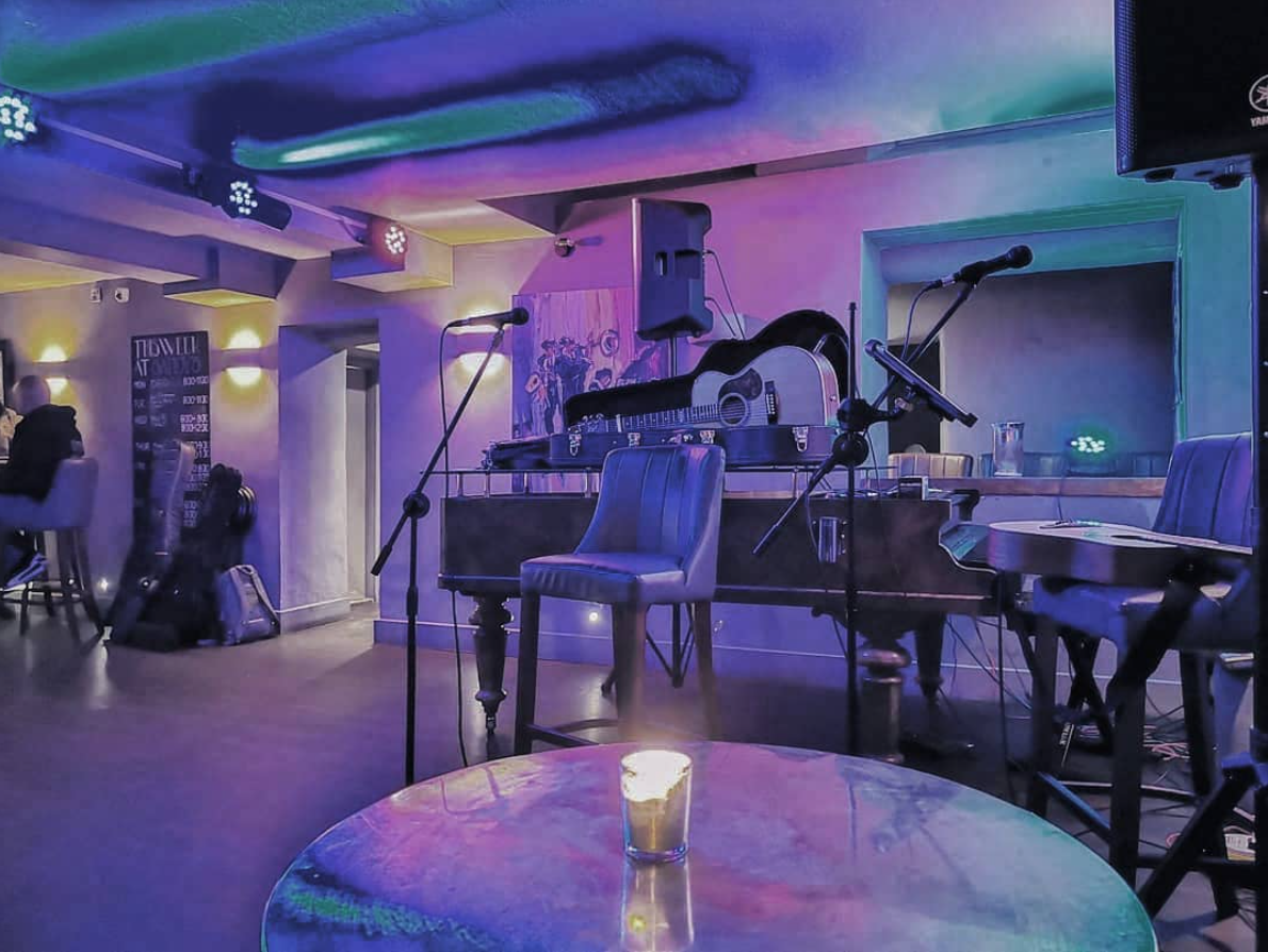 Cozy basement venue at Sandy's Piano Bar for intimate live performances and events.