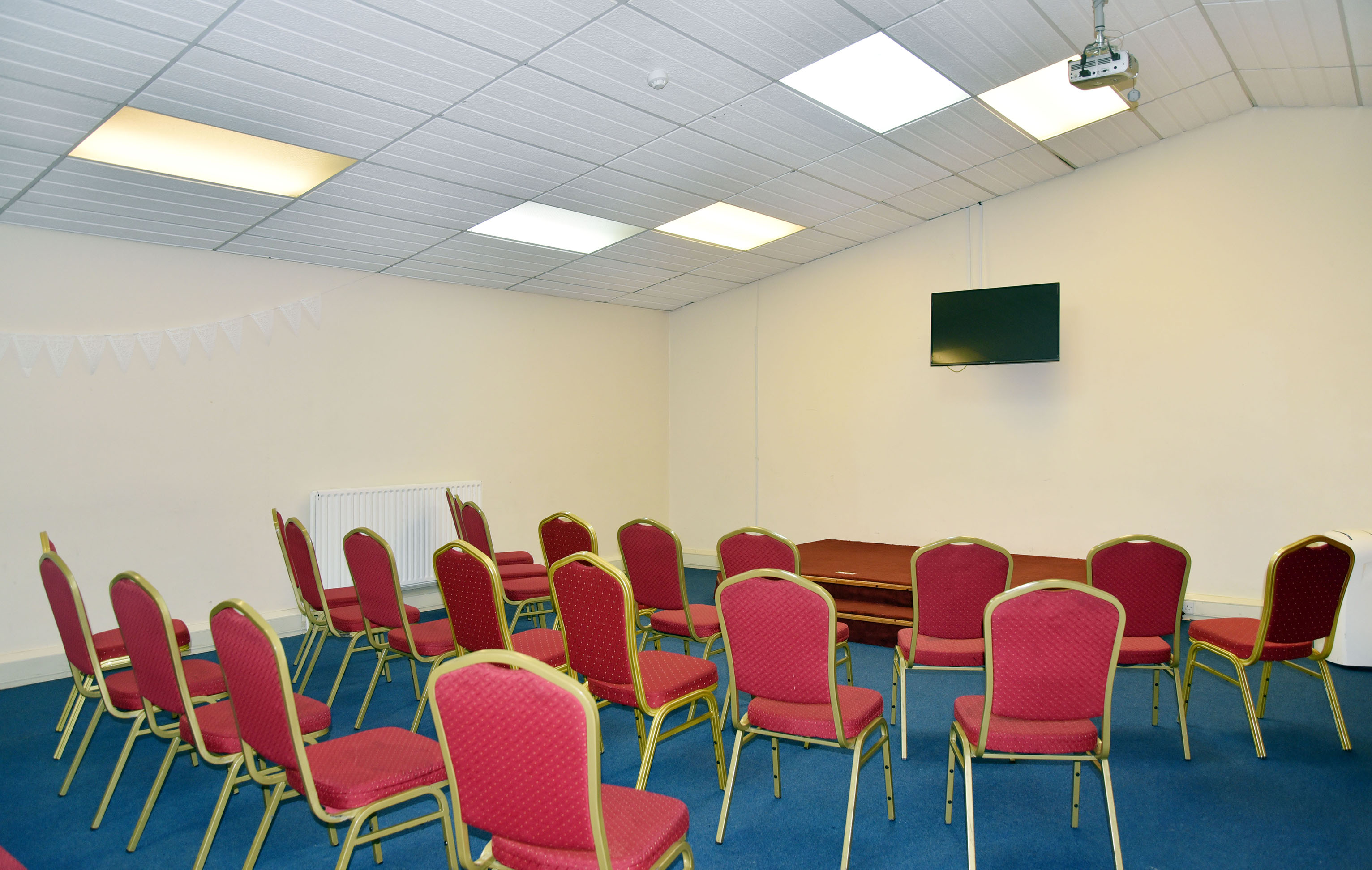 Mitcham Business Event Centre meeting room with red chairs, ideal for presentations and events.