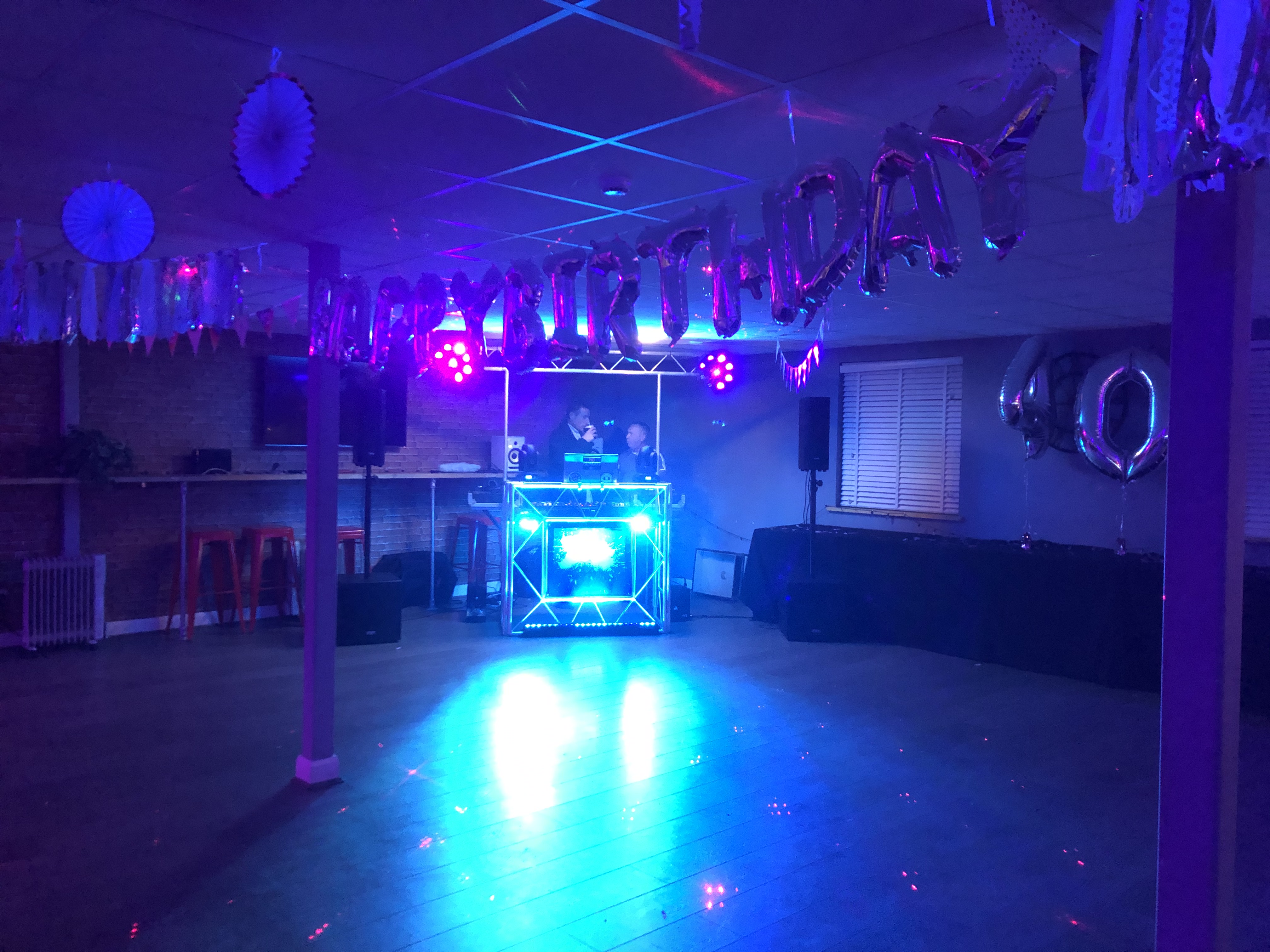 Vibrant birthday celebration venue with DJ booth and colorful decor at Lagoona Bar & Grill.