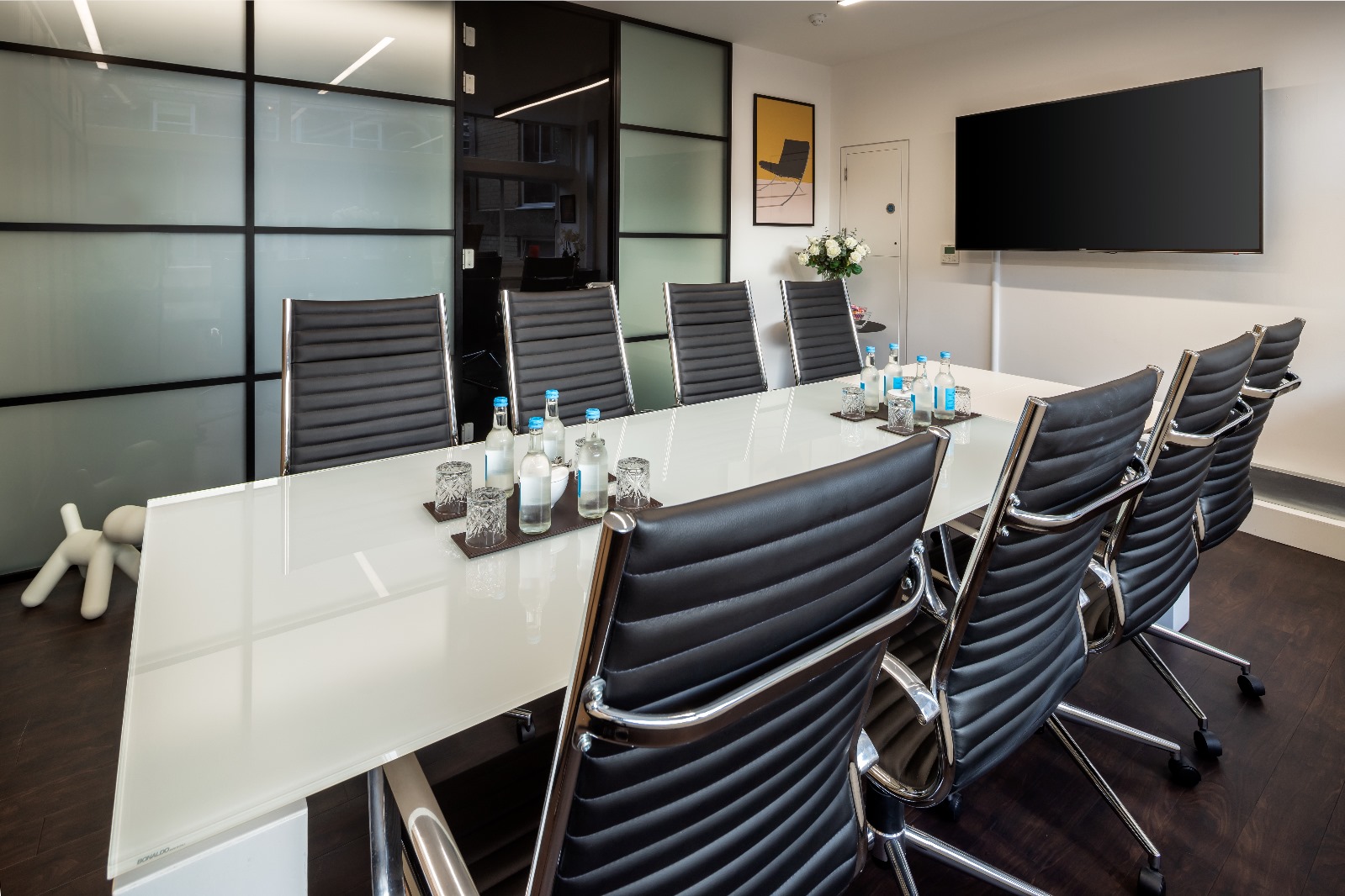 Modern conference room with glass table, ideal for professional meetings and events.