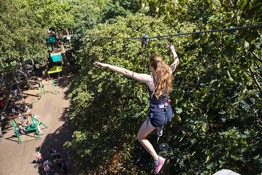 Go Ape Battersea zip line team-building activity in lush outdoor setting.