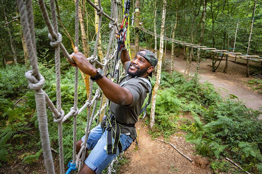 Individual on ropes course at Go Ape - Black Park, ideal for team-building events.