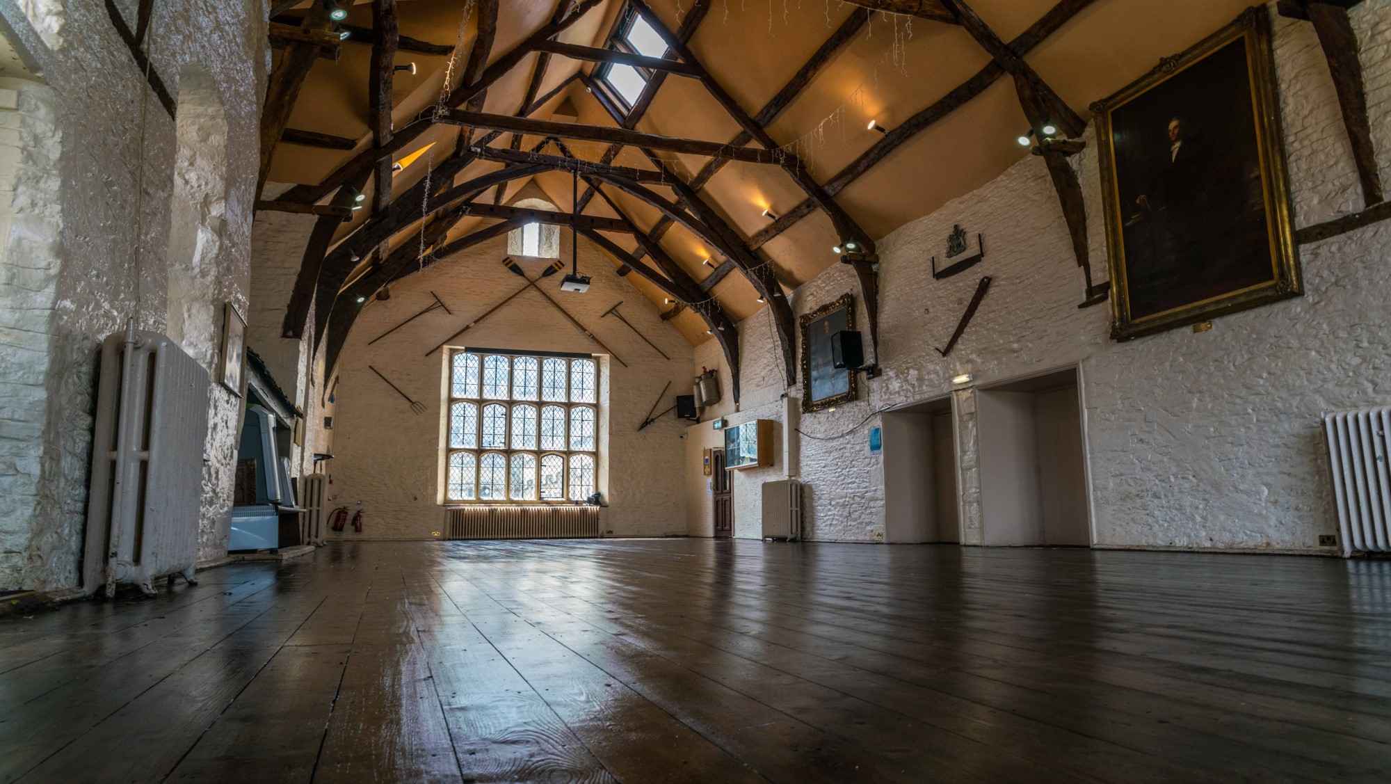 Spacious event venue with wooden beams, ideal for weddings and corporate meetings.