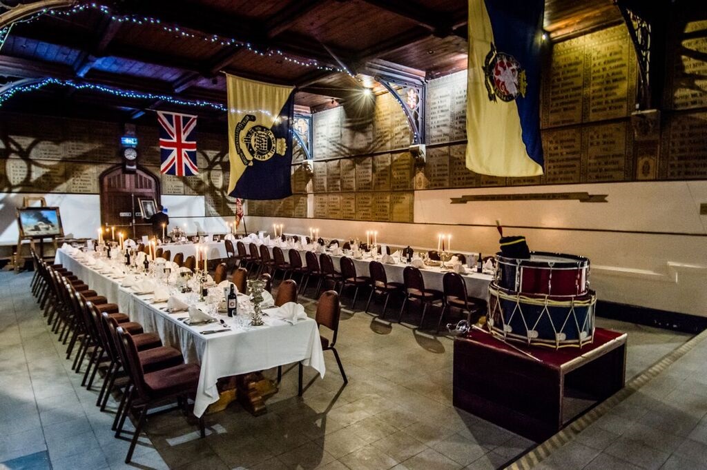 Elegant banquet table setup in historic Royal Agricultural University for formal events.